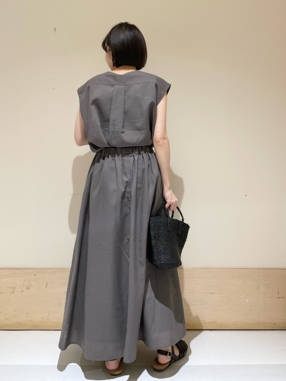 グレー系のシャツ/ブラウス、グレー系のスカート、ブラック系のサンダルを着用したレディースの夏コーディネートの6枚目の写真