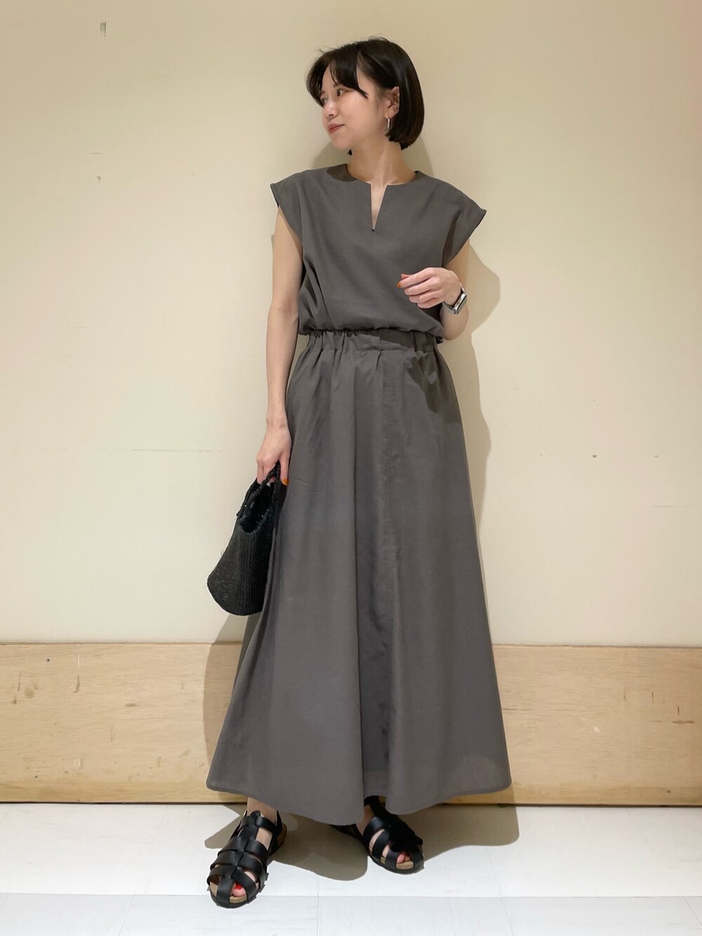グレー系のシャツ/ブラウス、グレー系のスカート、ブラック系のサンダルを着用したレディースの夏コーディネートの3枚目の写真