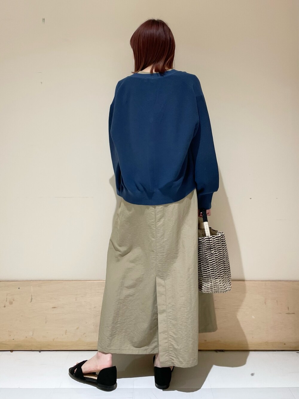 ベージュ系のワンピース、ブルー系のニット/セーター、ブラック系のショルダーバッグを着用したレディースの春コーディネートの6枚目の写真