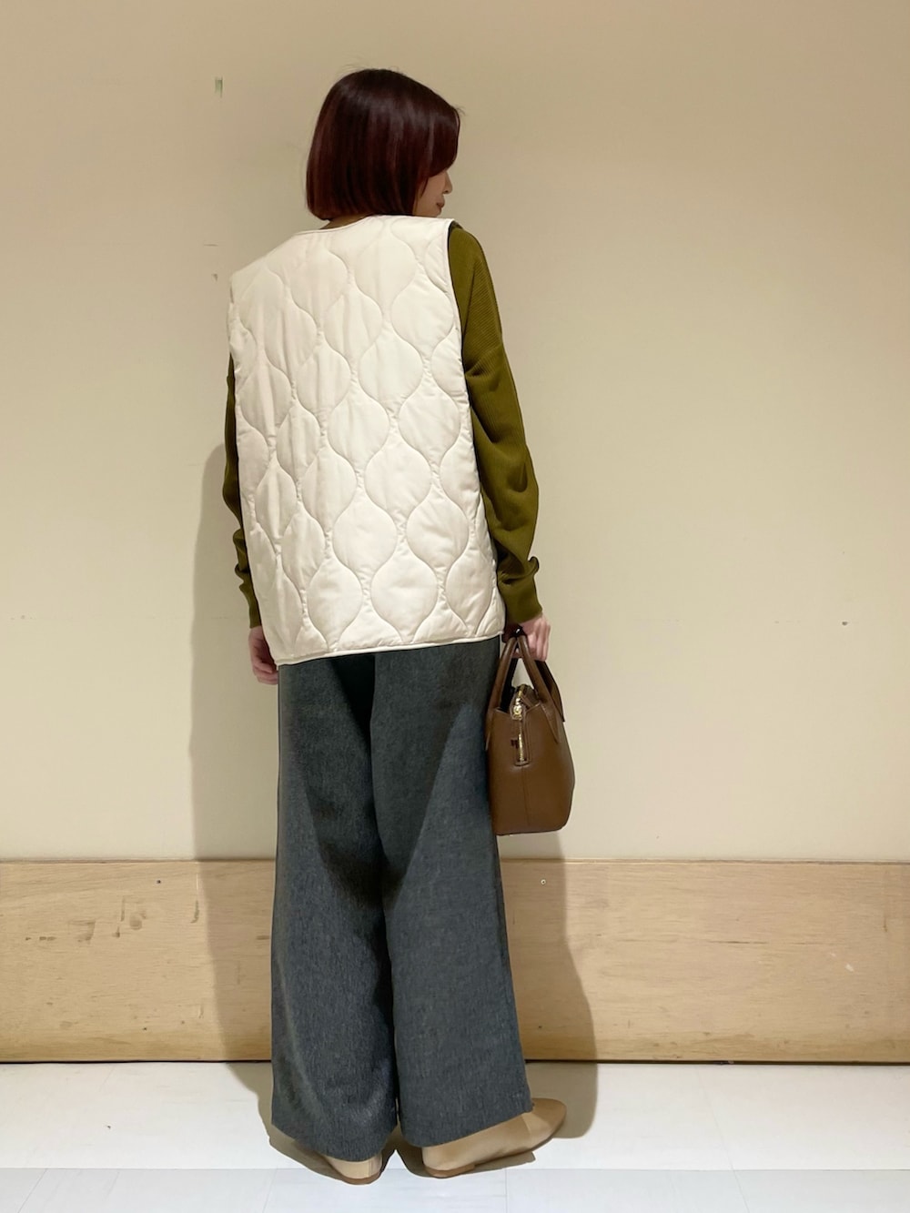 ゴールド系のパンプス、ブラウン系のショルダーバッグ、イエロー系のTシャツ/カットソーを着用したレディースの秋コーディネートの7枚目の写真