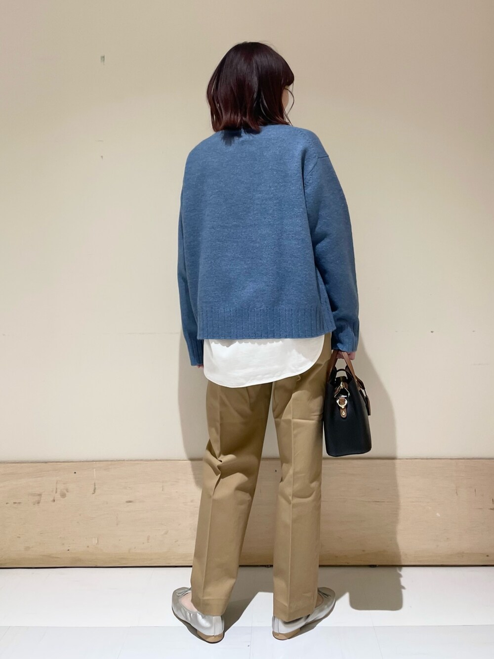 ホワイト系のTシャツ/カットソー、ブルー系のニット/セーター、シルバー系のバレエシューズを着用したレディースの冬コーディネートの7枚目の写真