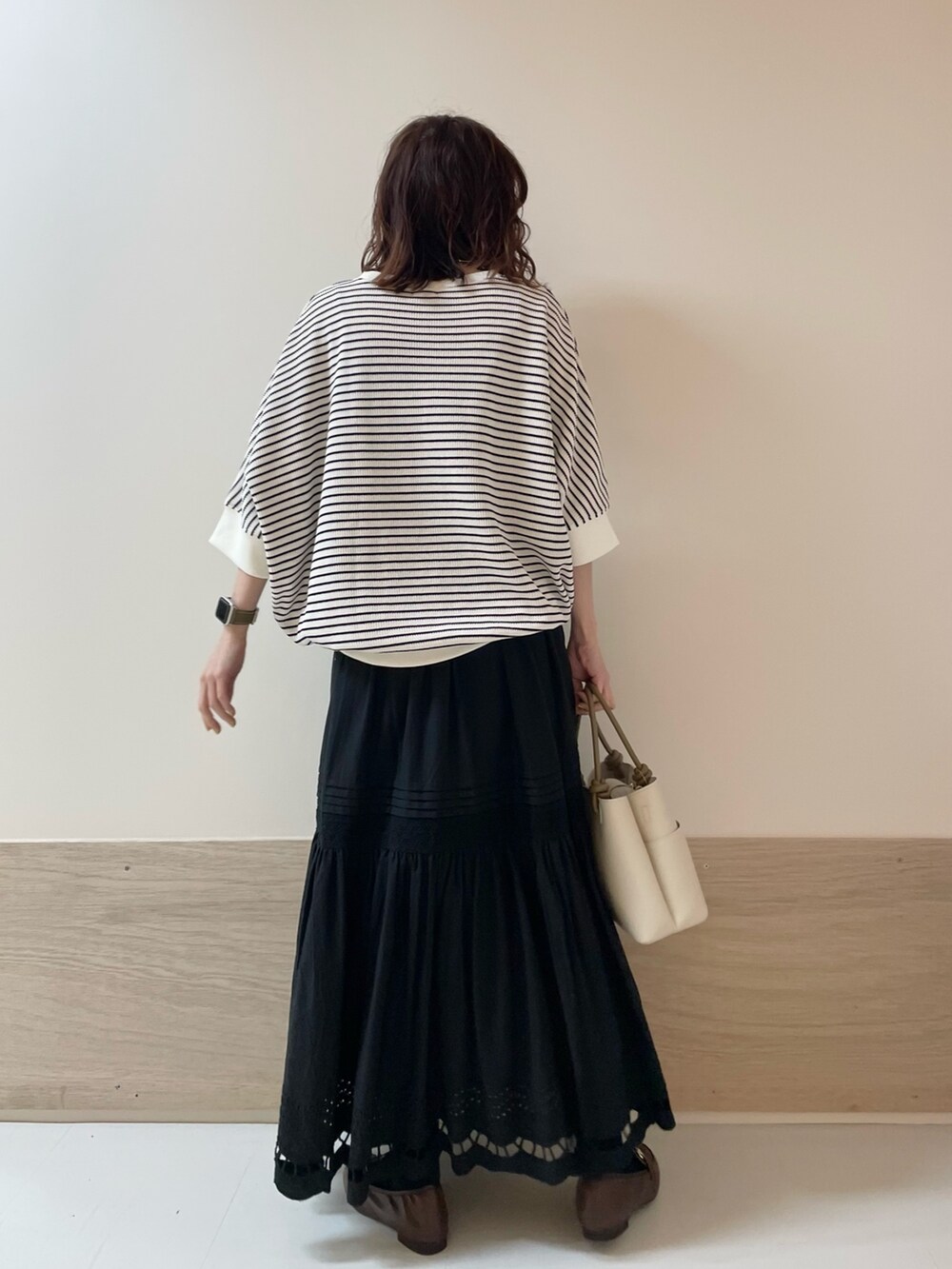 ブラウン系のローファー、ブラック系のスカート、ホワイト系のTシャツ/カットソーを着用したレディースの春コーディネートの5枚目の写真