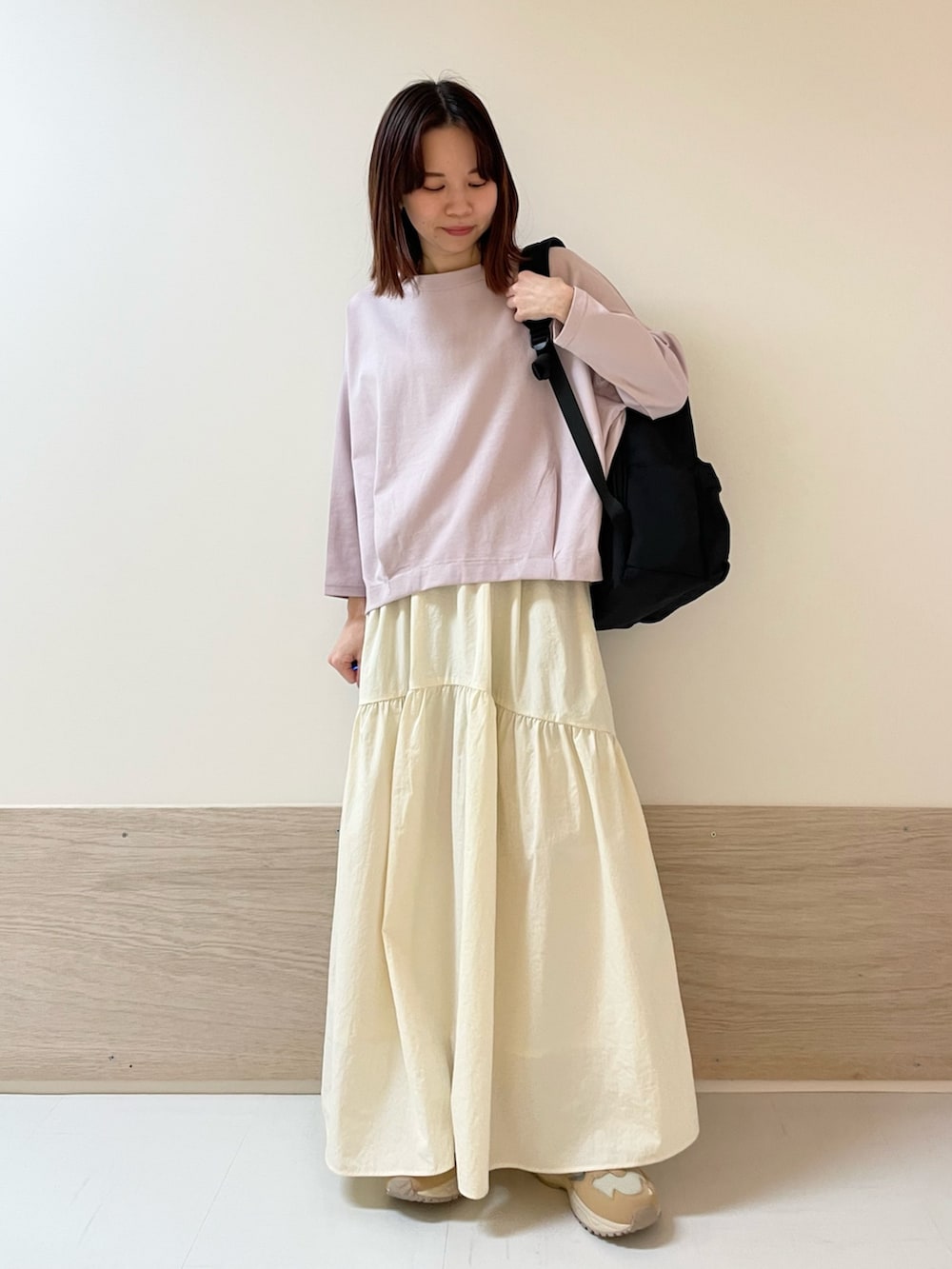 ホワイト系のスカート、ピンク系のTシャツ/カットソー、ベージュ系のスニーカーを着用したレディースの春コーディネートの2枚目の写真