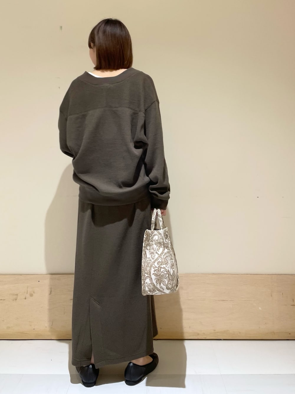 ベージュ系のトートバッグ、ホワイト系のタンクトップ、グレー系のカーディガン/ボレロを着用したレディースの秋コーディネートの6枚目の写真