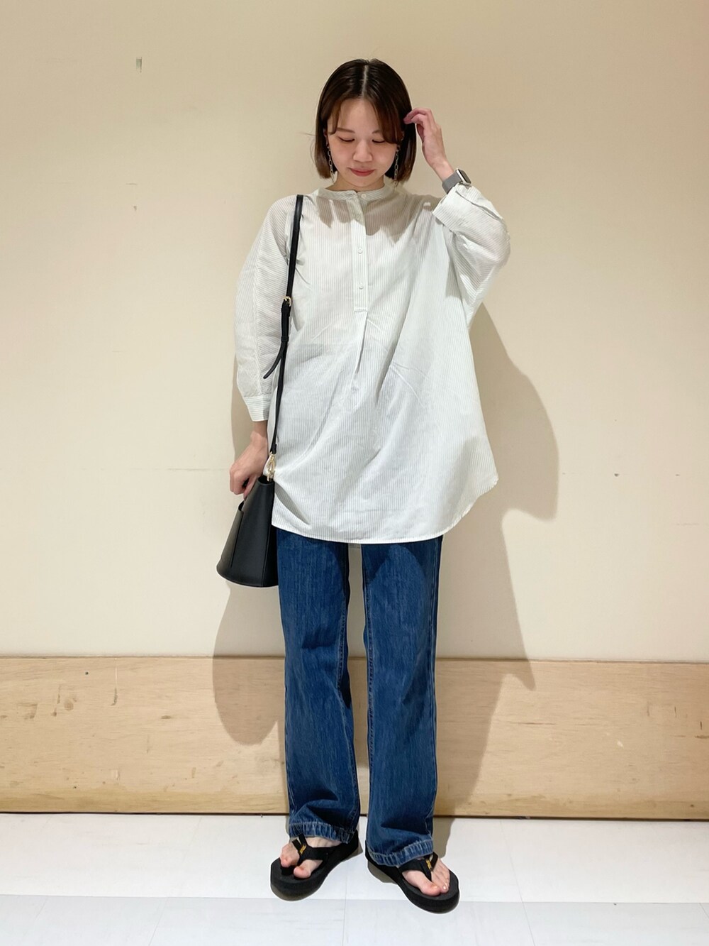 グリーン系のシャツ/ブラウス、ブルー系のデニムパンツ、ブラック系のサンダルを着用したレディースの夏コーディネートの2枚目の写真