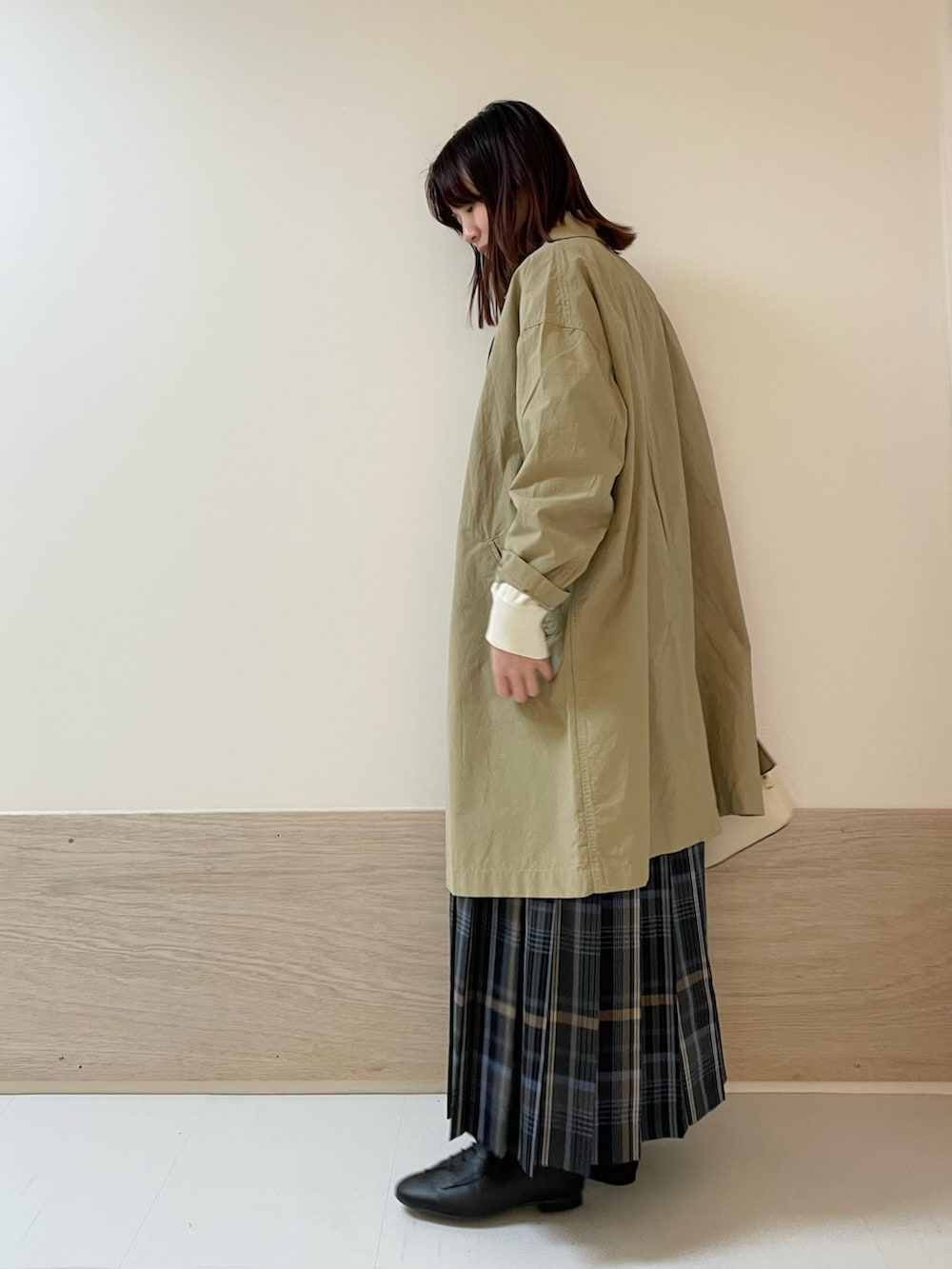 グレー系のスカート、ホワイト系のニット/セーター、ベージュ系のその他アウターを着用したレディースの春コーディネートの6枚目の写真