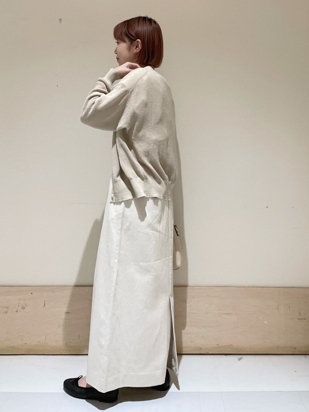 ベージュ系のスカート、ベージュ系のカーディガン/ボレロ、ホワイト系のTシャツ/カットソーを着用したレディースの春コーディネートの5枚目の写真