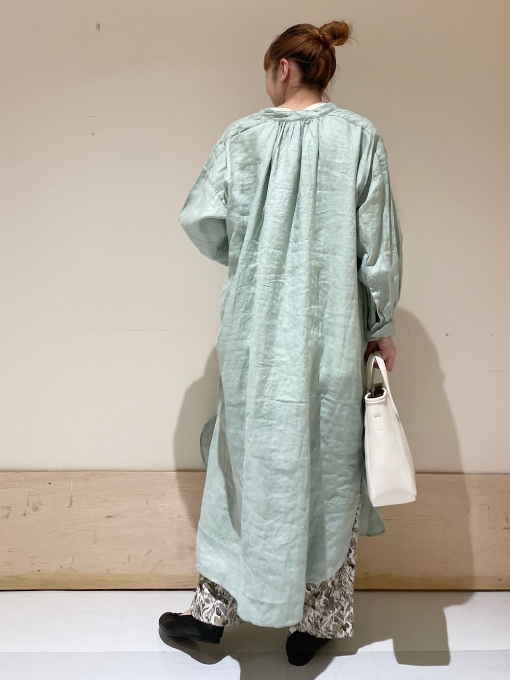 グリーン系のワンピース、ホワイト系のTシャツ/カットソー、ホワイト系のトートバッグを着用したレディースの春コーディネートの5枚目の写真