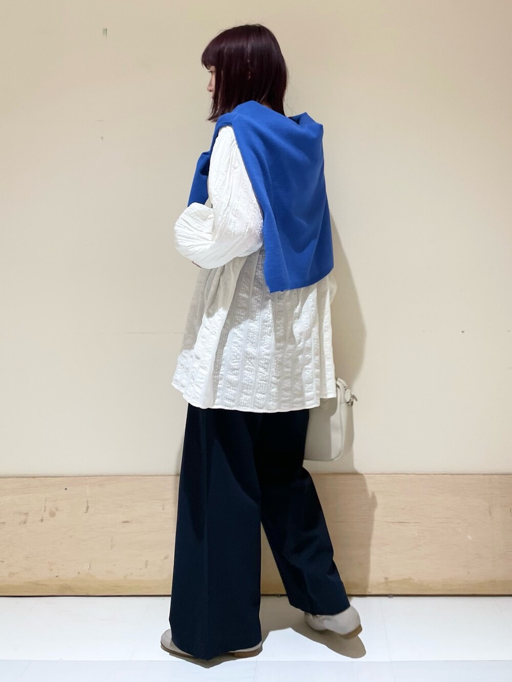 ブルー系のその他パンツ、ホワイト系のシャツ/ブラウス、ブルー系のニット/セーターを着用したレディースの春コーディネートの4枚目の写真