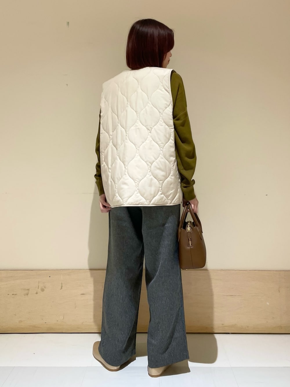 ゴールド系のパンプス、ブラウン系のショルダーバッグ、イエロー系のTシャツ/カットソーを着用したレディースの秋コーディネートの6枚目の写真