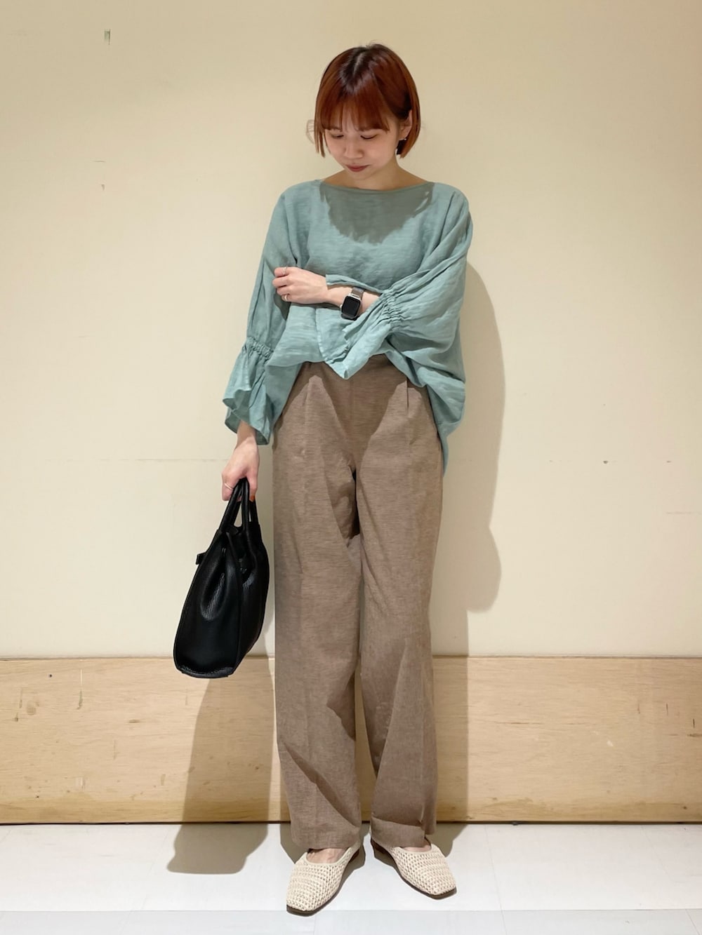 グリーン系のシャツ/ブラウス、ブラック系のトートバッグ、ホワイト系のバレエシューズを着用したレディースの春コーディネートの4枚目の写真