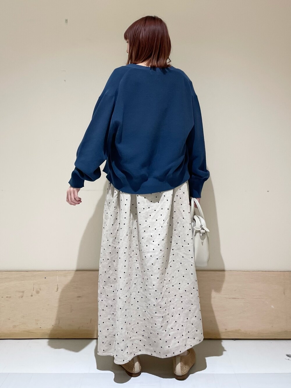 ベージュ系のショルダーバッグ、ベージュ系のパンプス、ブルー系のニット/セーターを着用したレディースの春コーディネートの7枚目の写真