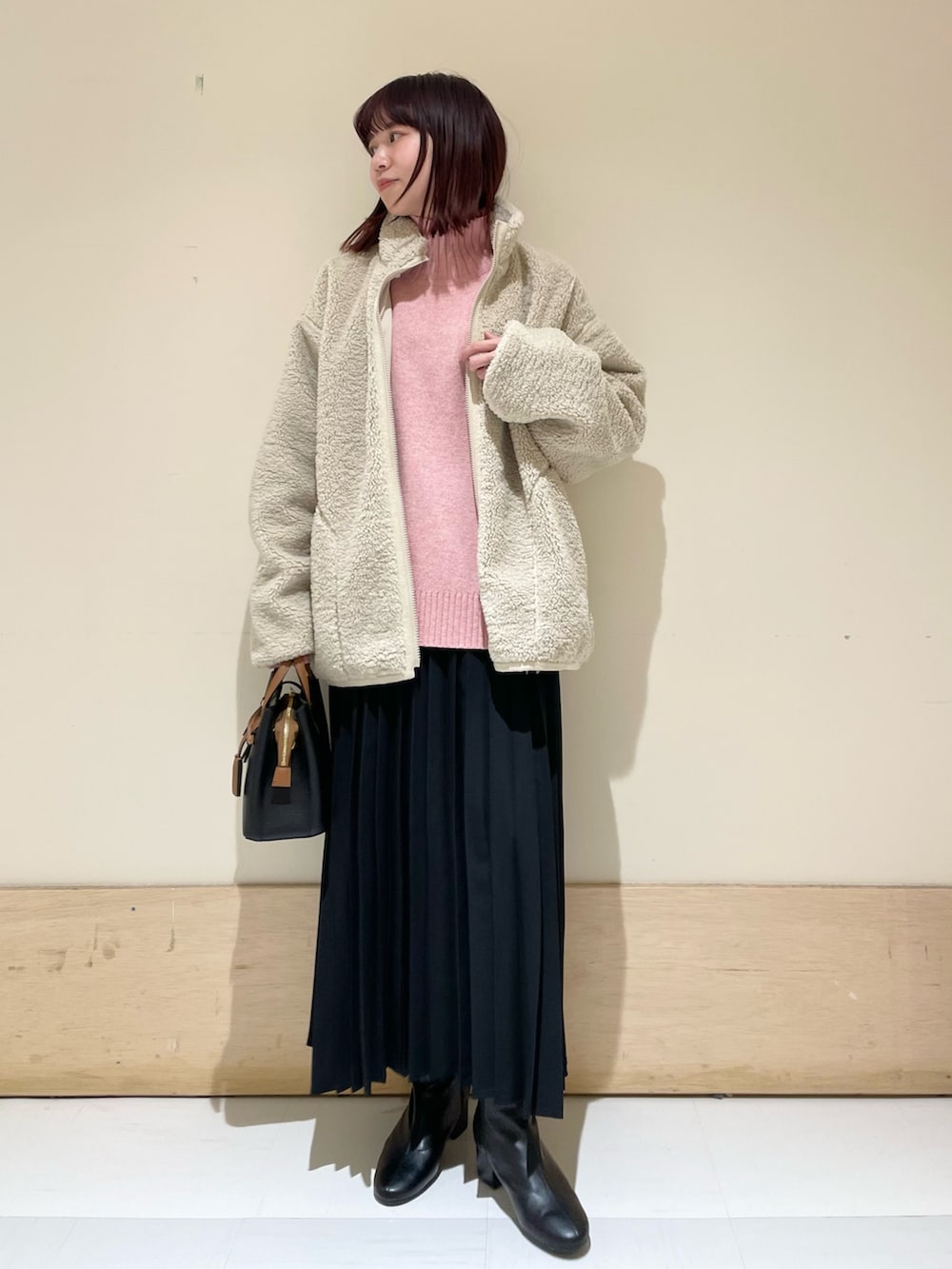 ピンク系のニット/セーター、ホワイト系のブルゾン、ブラック系のスカートを着用したレディースの冬コーディネートの3枚目の写真