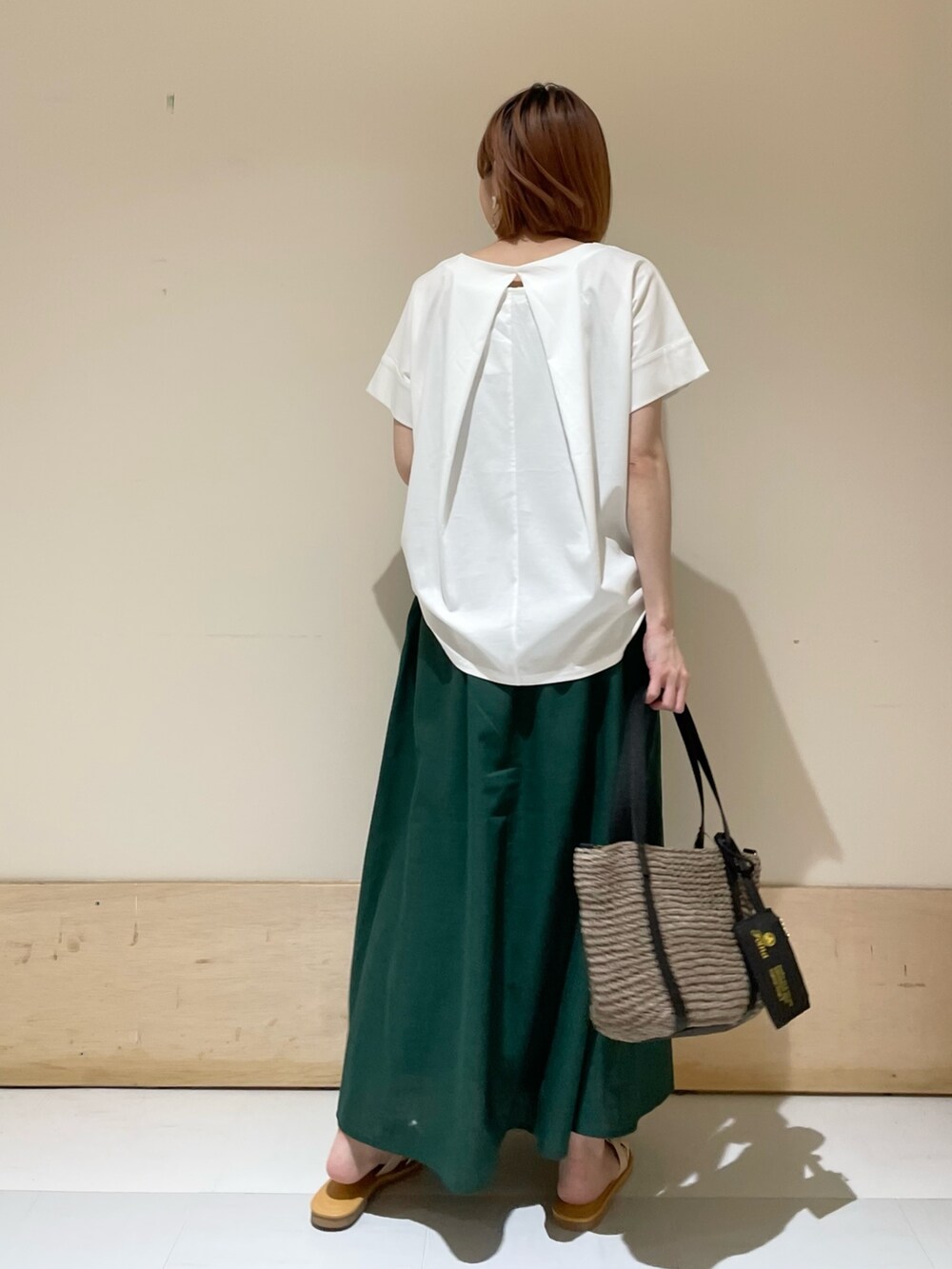 ホワイト系のTシャツ/カットソー、グレー系のトートバッグ、グリーン系のスカートを着用したレディースの夏コーディネートの7枚目の写真