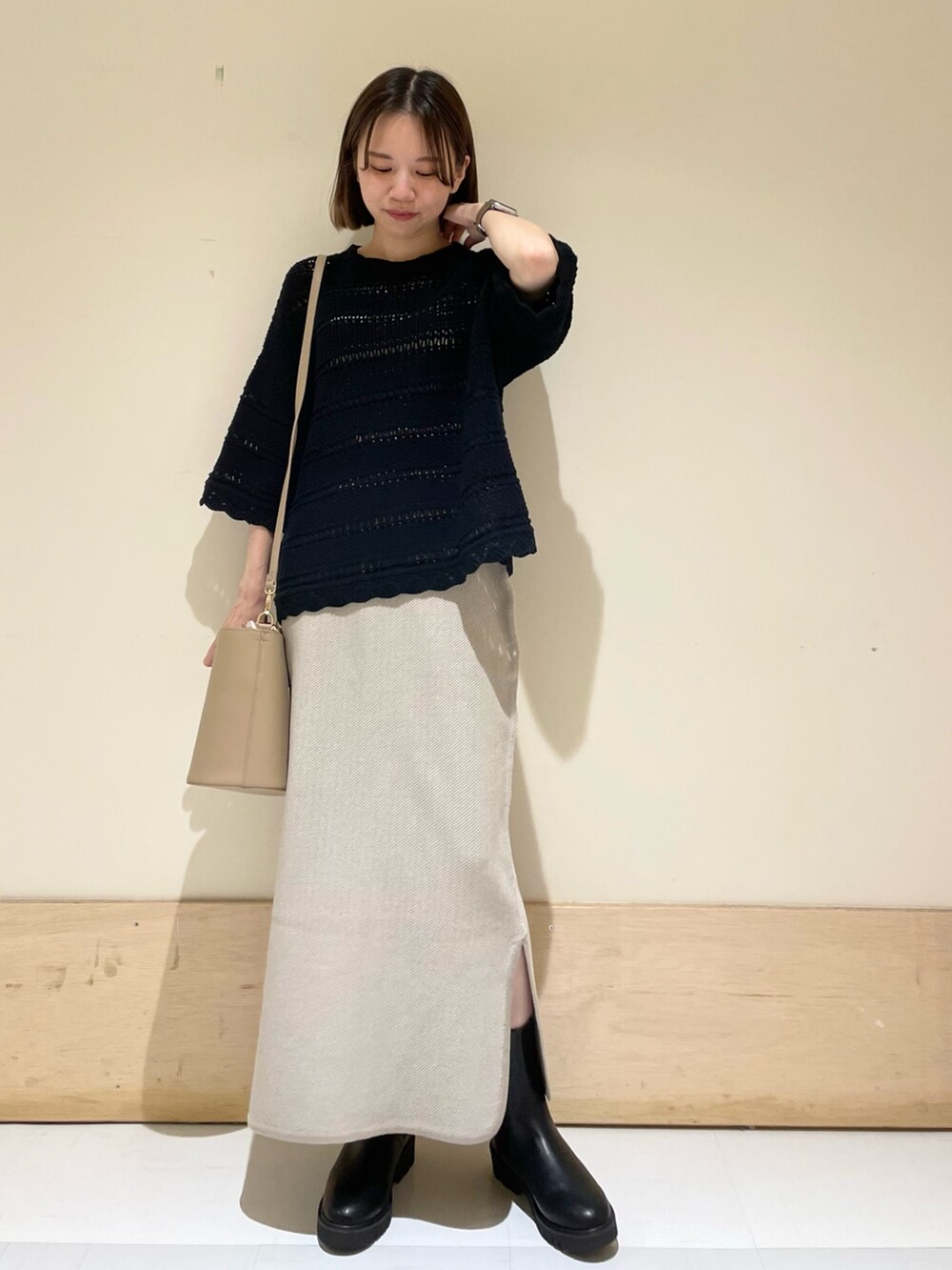 ベージュ系のショルダーバッグ、ブラック系のブーツ、ブラック系のニット/セーターを着用したレディースの秋コーディネートの4枚目の写真