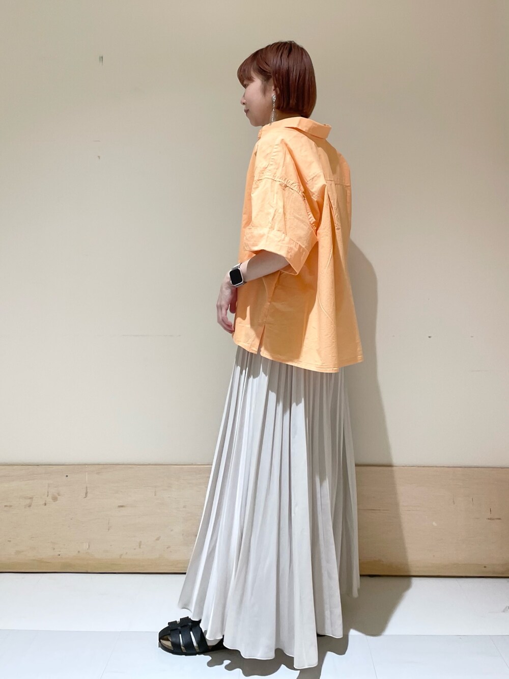 ブラック系のショルダーバッグ、ブラック系のサンダル、ホワイト系のスカートを着用したレディースの春コーディネートの3枚目の写真