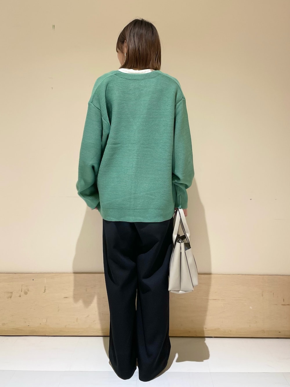 グリーン系のカーディガン/ボレロ、ホワイト系のTシャツ/カットソー、グレー系のトートバッグを着用したレディースの秋コーディネートの5枚目の写真