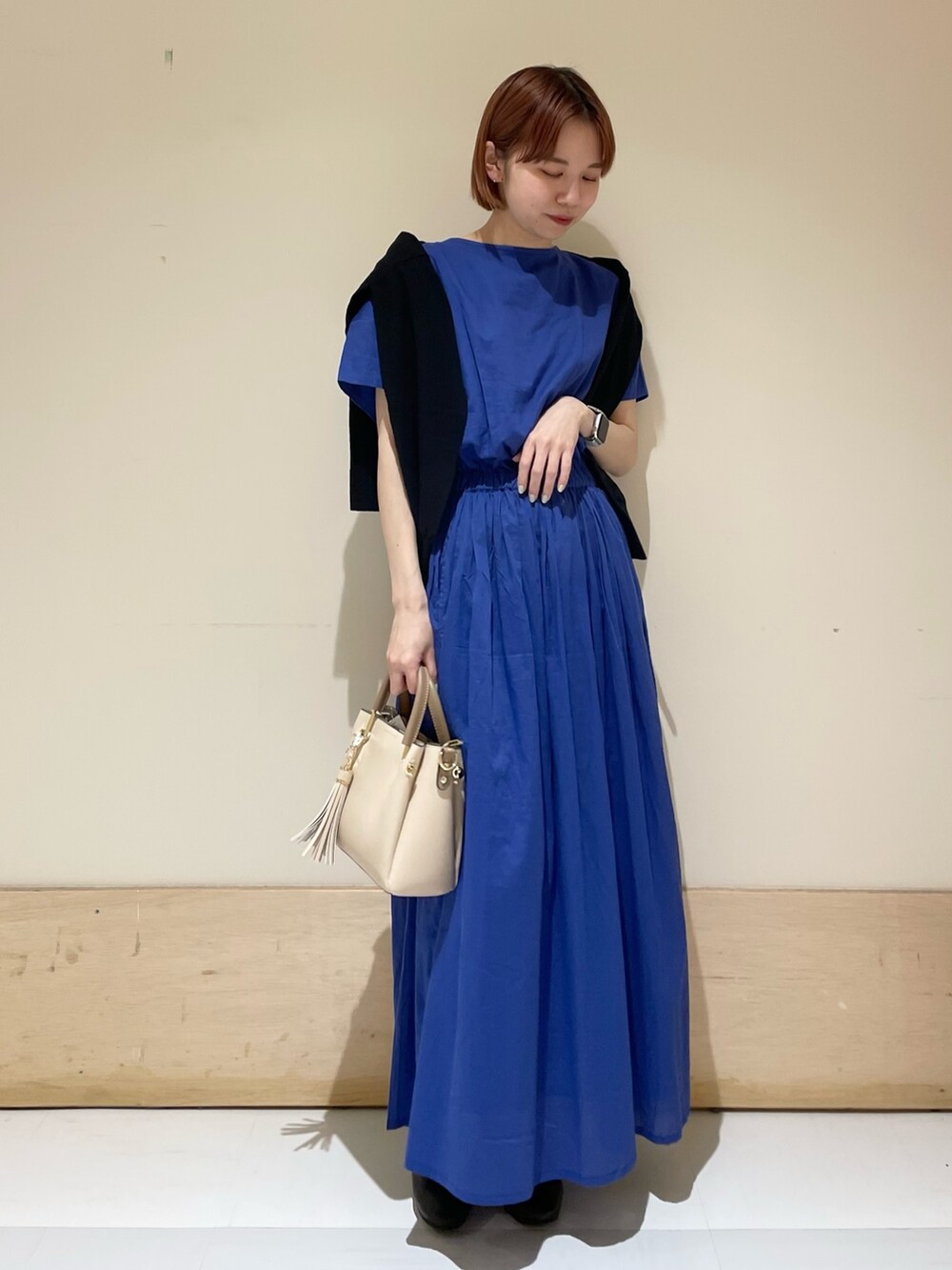 ブルー系のワンピース、ブラック系のカーディガン/ボレロ、ホワイト系のトートバッグを着用したレディースの春コーディネートの5枚目の写真