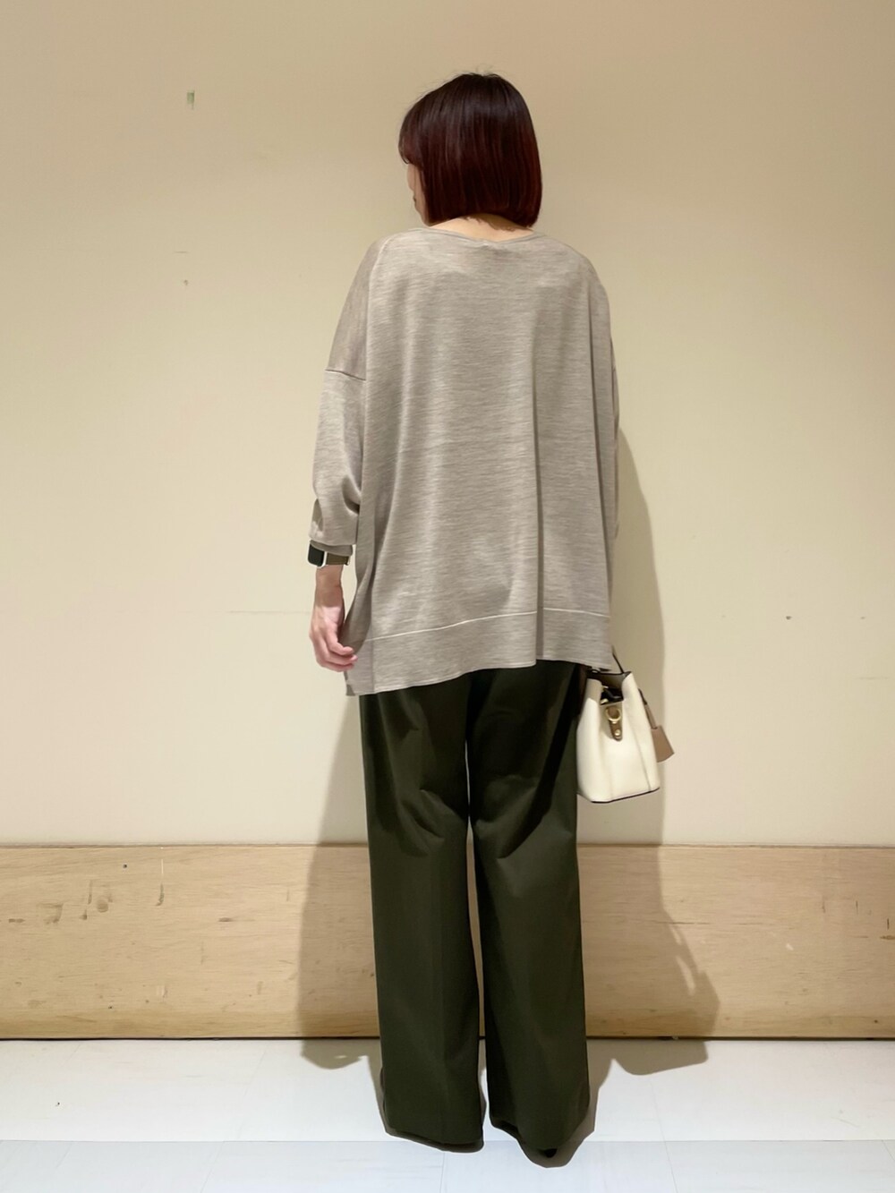 ブラック系のパンプス、ベージュ系のニット/セーター、ホワイト系のハンドバッグを着用したレディースの秋コーディネートの8枚目の写真