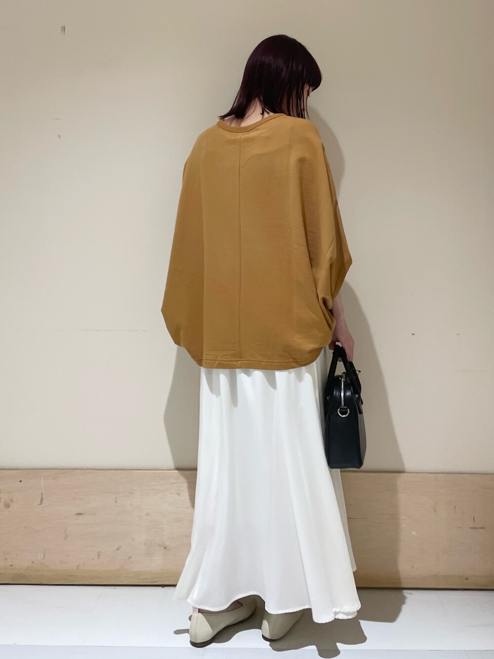 ホワイト系のスカート、イエロー系のTシャツ/カットソー、ブラック系のショルダーバッグを着用したレディースの春コーディネートの7枚目の写真