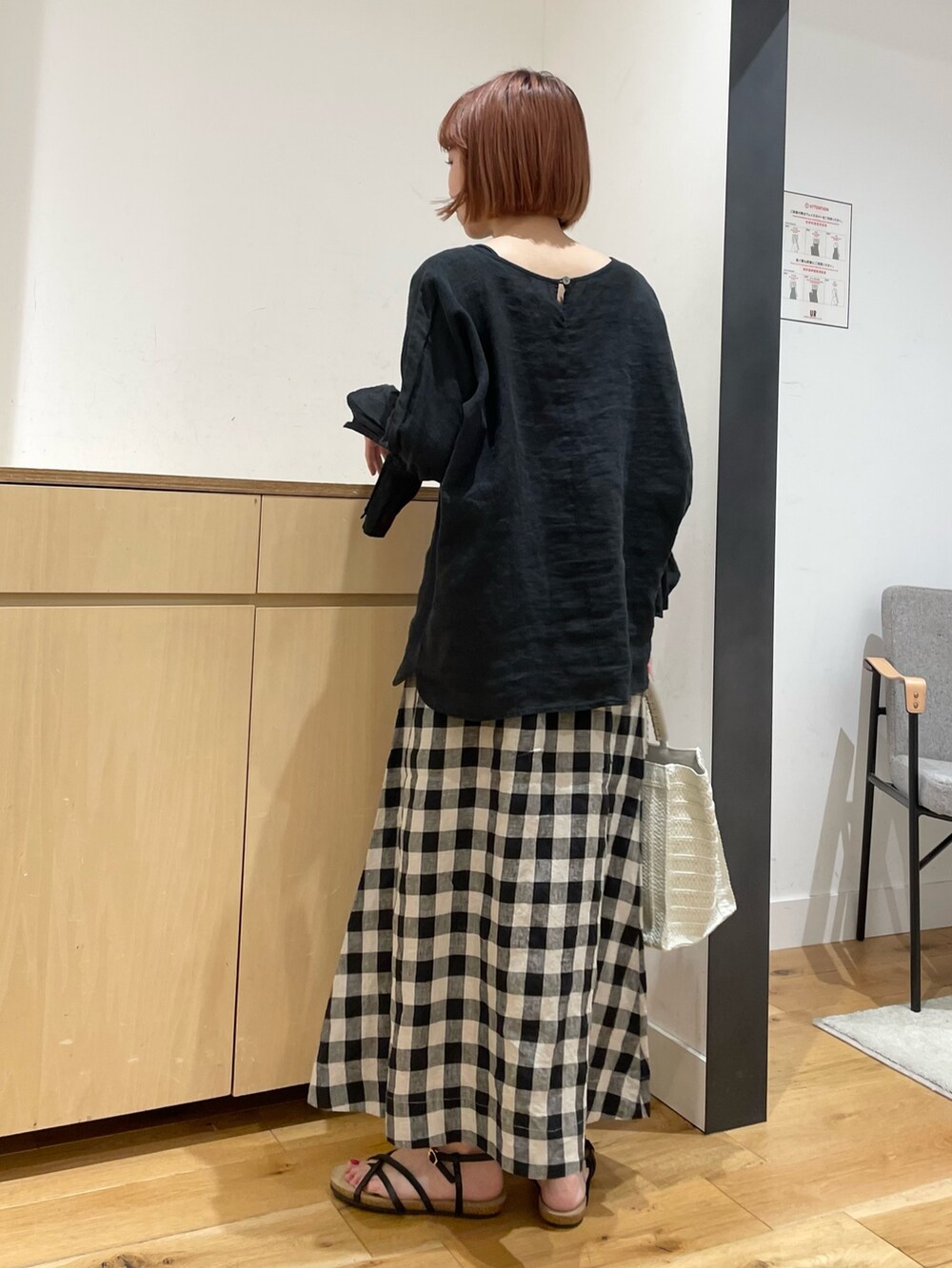 ブラック系のスカート、ベージュ系のトートバッグ、ブラック系のシャツ/ブラウスを着用したレディースの春コーディネートの5枚目の写真