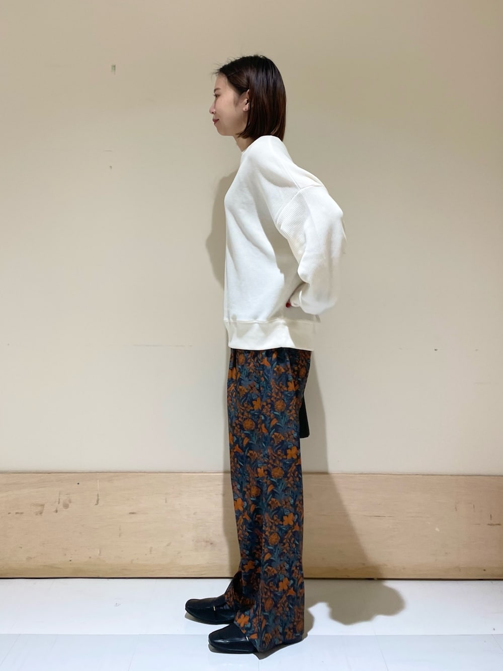 オレンジ系のその他パンツ、ブラック系のハンドバッグ、ブラック系のローファーを着用したレディースの秋コーディネートの5枚目の写真