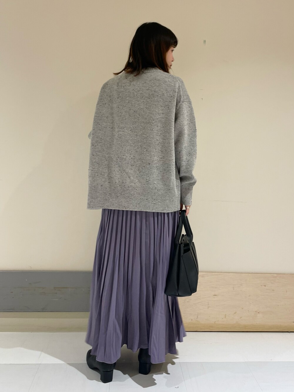 ブラック系のトートバッグ、パープル系のスカート、グレー系のニット/セーターを着用したレディースの冬コーディネートの3枚目の写真