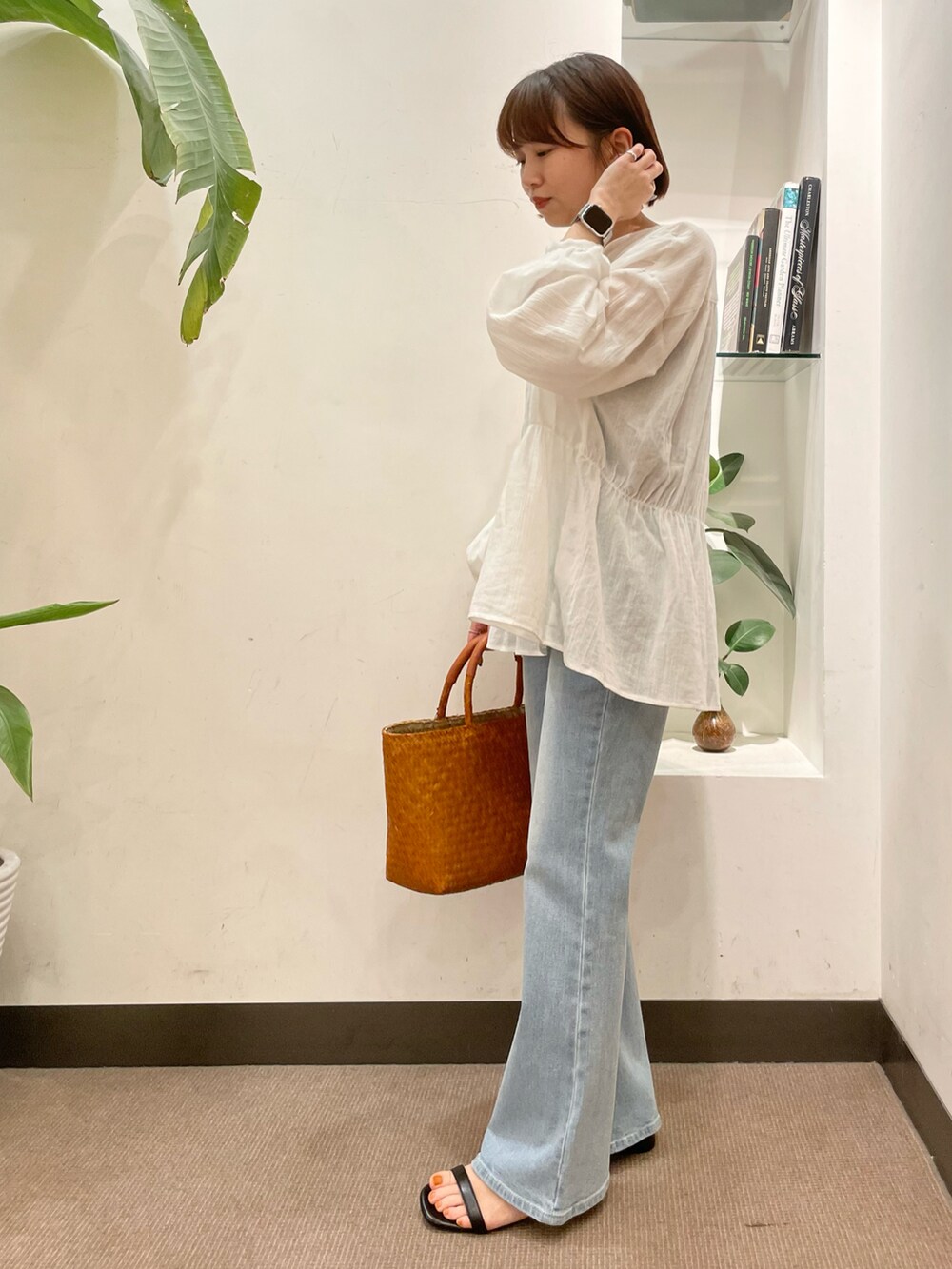 ブルー系のデニムパンツ、ブラック系のサンダル、ホワイト系のシャツ/ブラウスを着用したレディースの春コーディネートの4枚目の写真