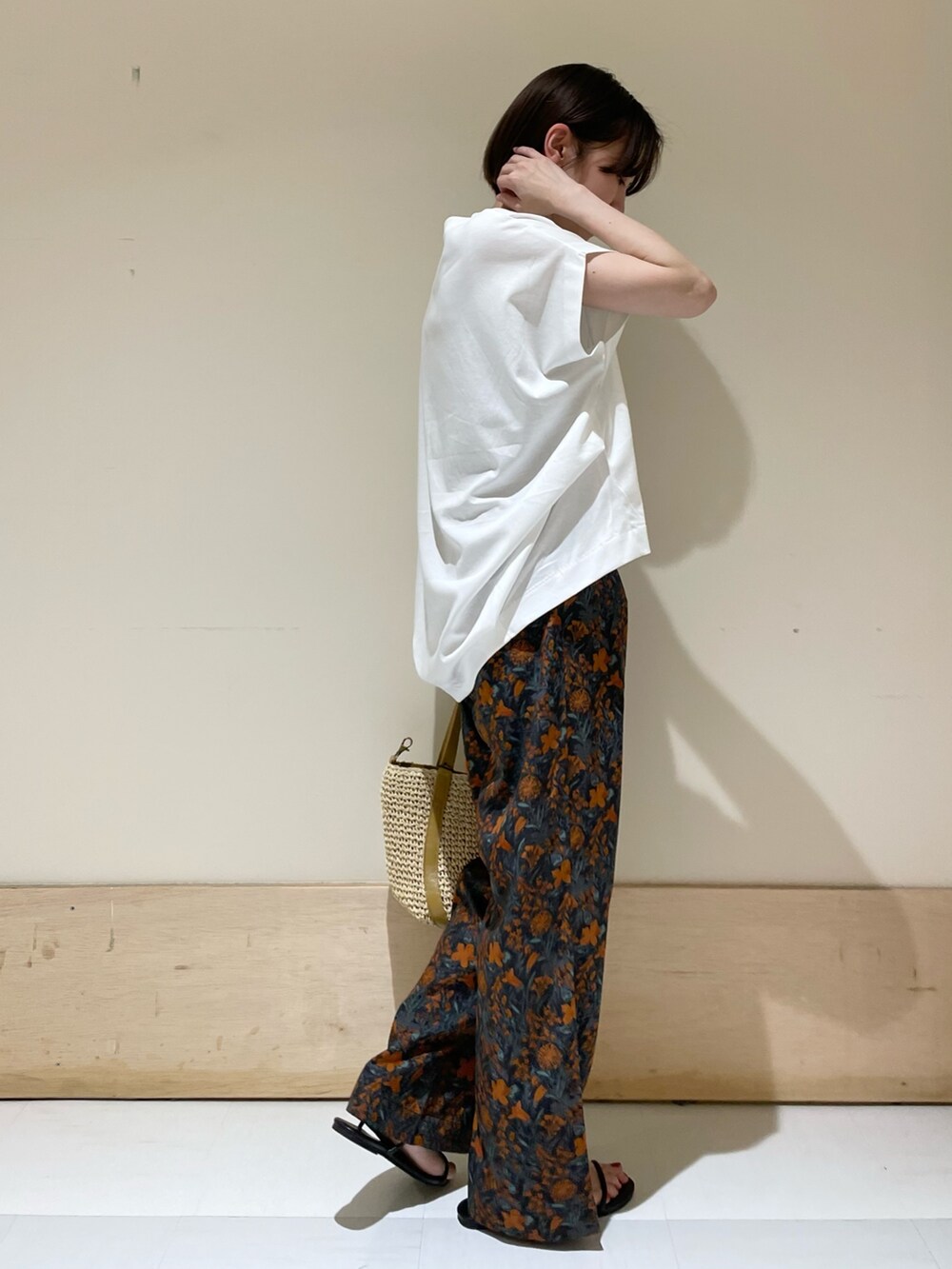 オレンジ系のその他パンツ、ホワイト系のTシャツ/カットソー、ベージュ系のトートバッグを着用したレディースの夏コーディネートの4枚目の写真