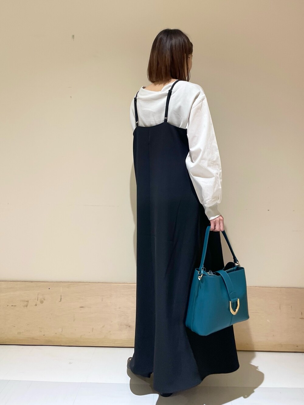 グレー系のTシャツ/カットソー、ブラック系のワンピース、ブルー系のハンドバッグを着用したレディースの秋コーディネートの6枚目の写真