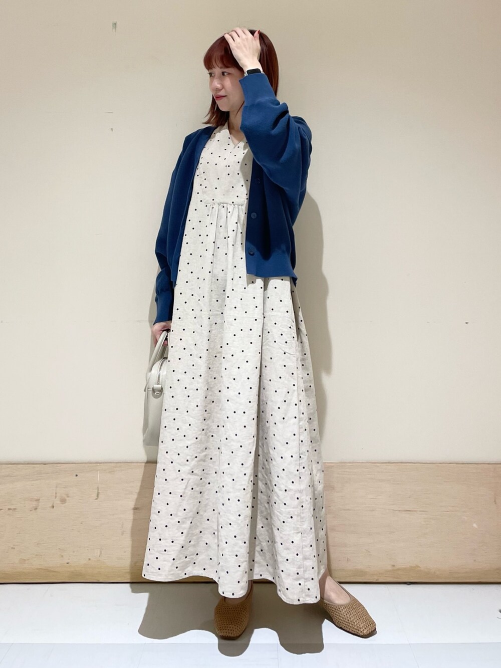 ベージュ系のショルダーバッグ、ベージュ系のパンプス、ブルー系のニット/セーターを着用したレディースの春コーディネートの3枚目の写真