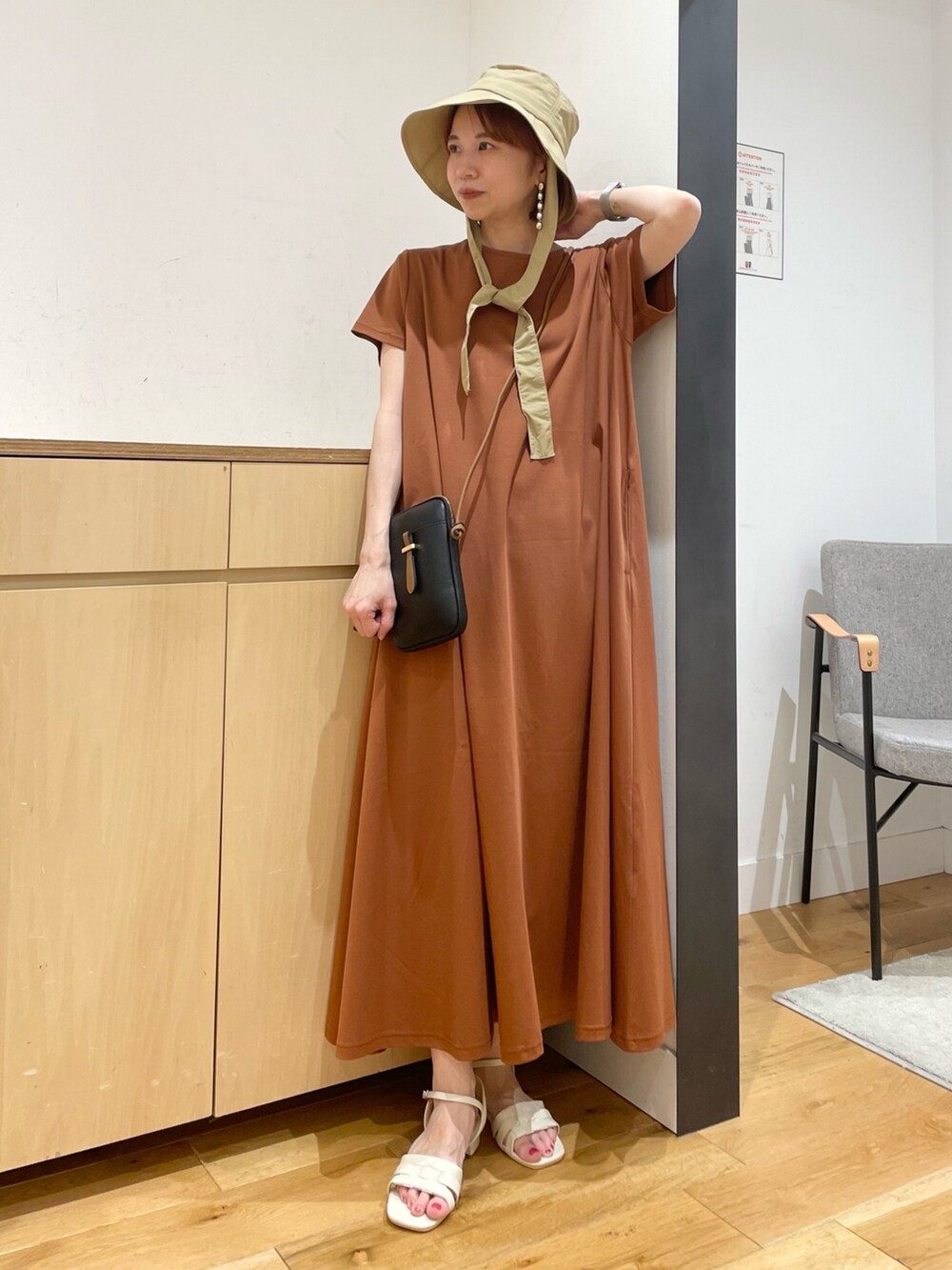 ホワイト系のサンダル、ブラウン系のワンピース、ブラック系のショルダーバッグを着用したレディースの夏コーディネートの3枚目の写真