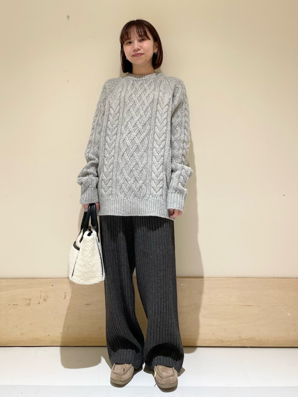 ホワイト系のショルダーバッグ、グレー系のニット/セーター、グレー系のその他パンツを着用したレディースの秋コーディネートの3枚目の写真