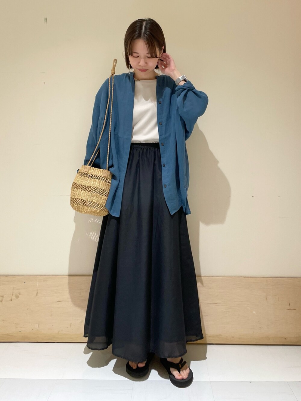 ブラック系のスカート、ベージュ系のショルダーバッグ、グレー系のTシャツ/カットソーを着用したレディースの夏コーディネートの2枚目の写真