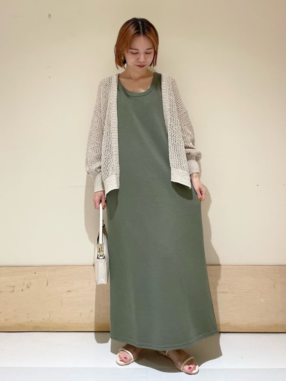 ベージュ系のショルダーバッグ、ホワイト系のサンダル、ホワイト系のカーディガン/ボレロを着用したレディースの夏コーディネートの2枚目の写真