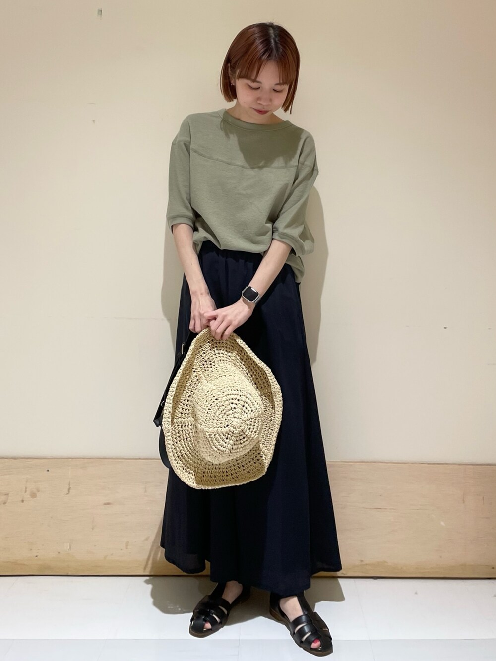 ブルー系のスカート、ブラック系のサンダル、グリーン系のTシャツ/カットソーを着用したレディースの春コーディネートの3枚目の写真