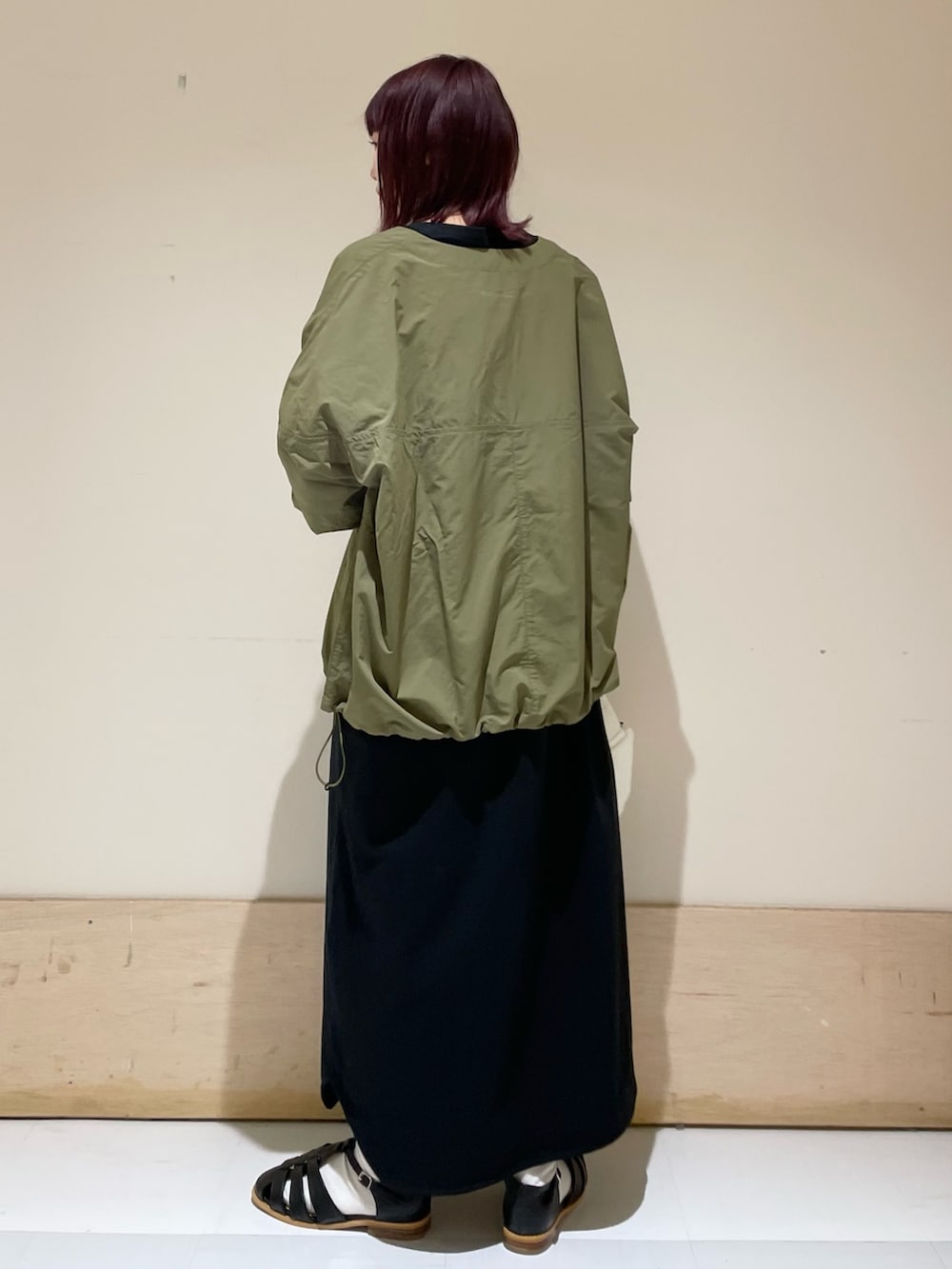 ホワイト系のハンドバッグ、ブラック系のワンピース、グリーン系のその他トップスを着用したレディースの春コーディネートの6枚目の写真