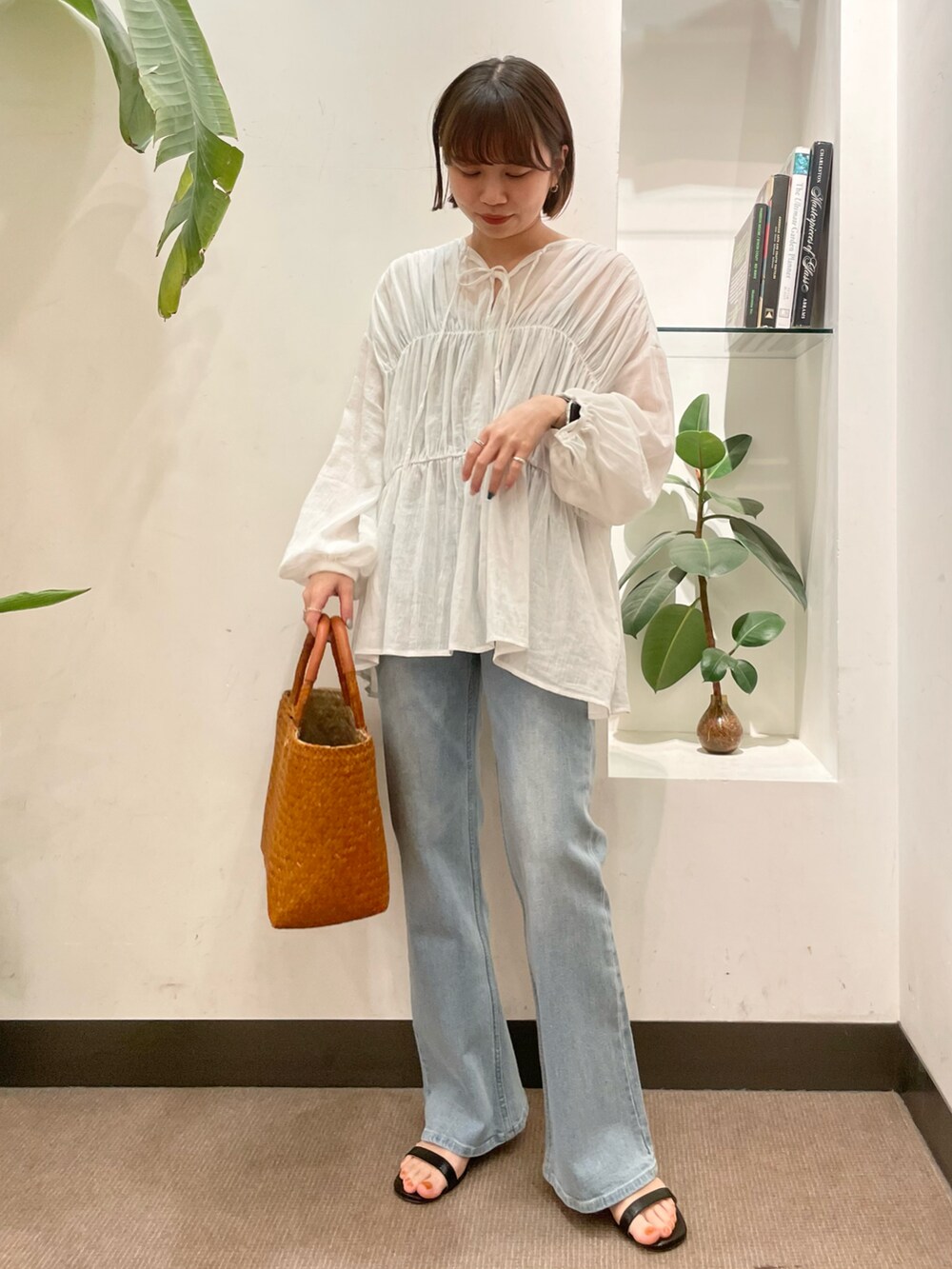 ブルー系のデニムパンツ、ブラック系のサンダル、ホワイト系のシャツ/ブラウスを着用したレディースの春コーディネートの2枚目の写真