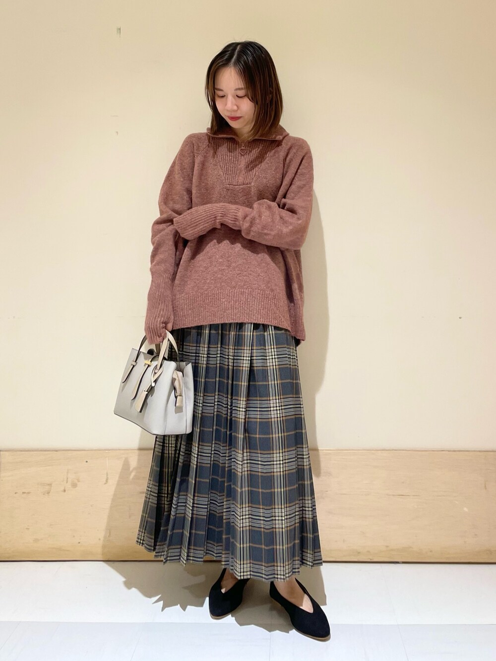 レッド系のニット/セーター、ブラック系のパンプス、グレー系のハンドバッグを着用したレディースの秋コーディネートの4枚目の写真