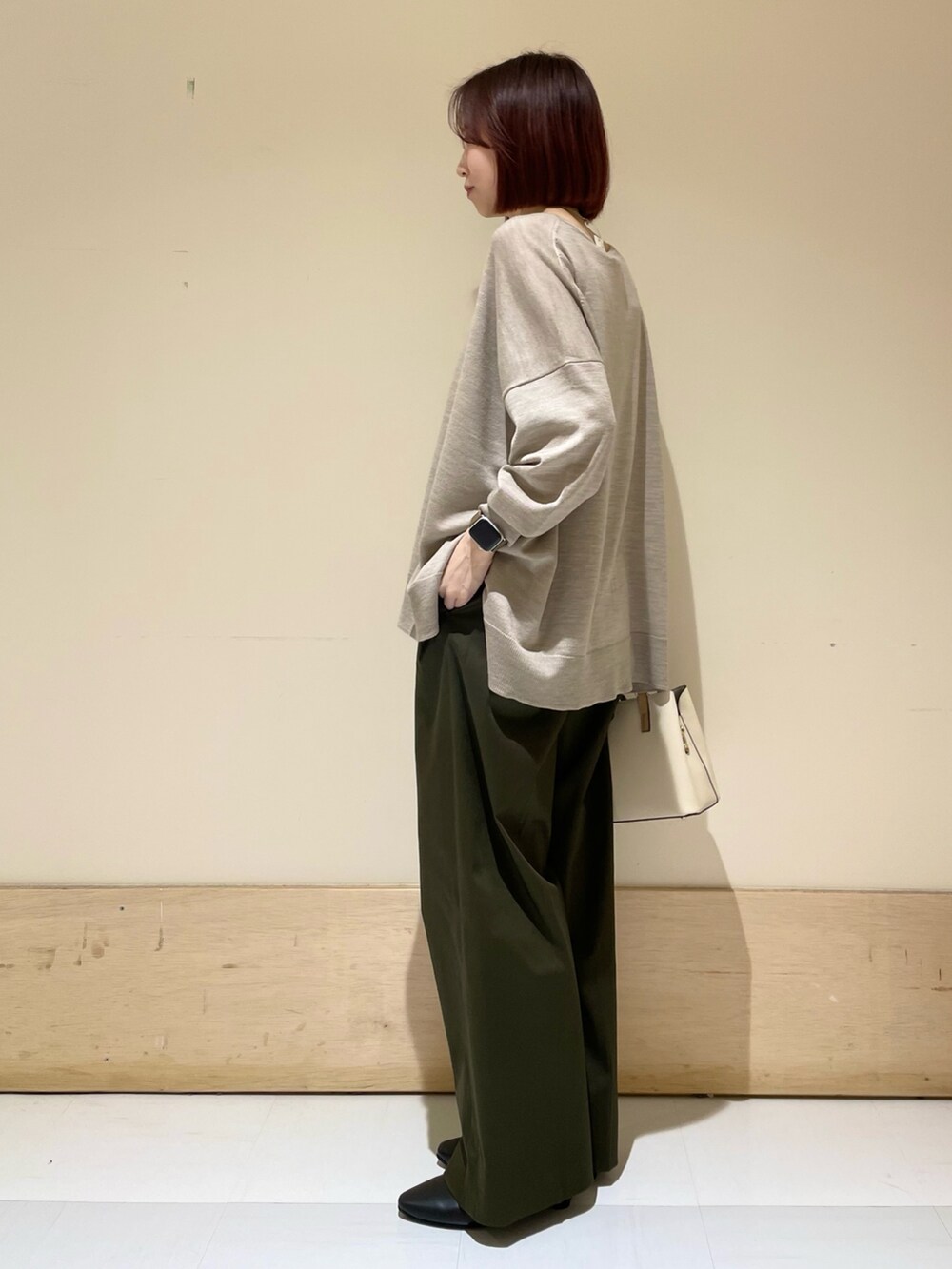 ブラック系のパンプス、ベージュ系のニット/セーター、ホワイト系のハンドバッグを着用したレディースの秋コーディネートの5枚目の写真