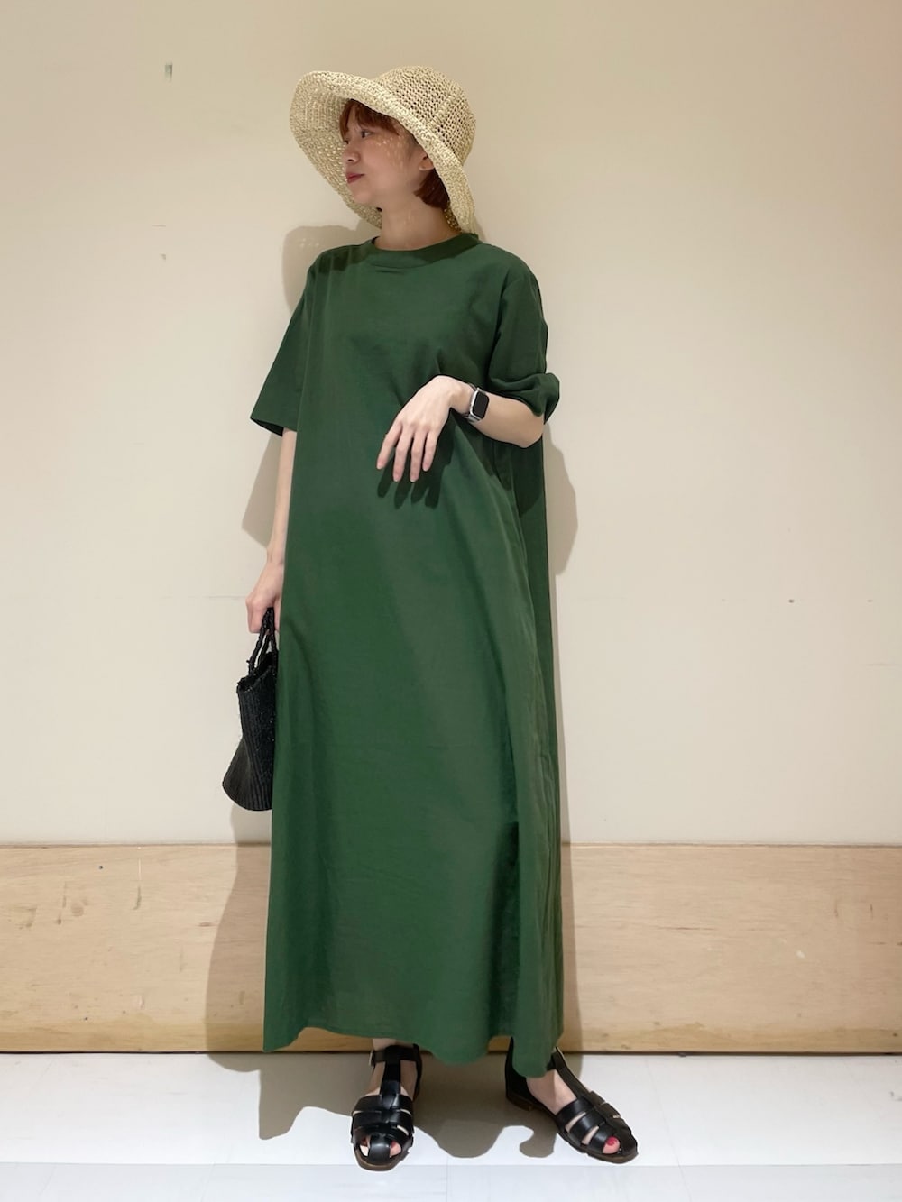 グリーン系のワンピース、ブラック系のサンダル、ブラック系のハンドバッグを着用したレディースの春コーディネートの9枚目の写真