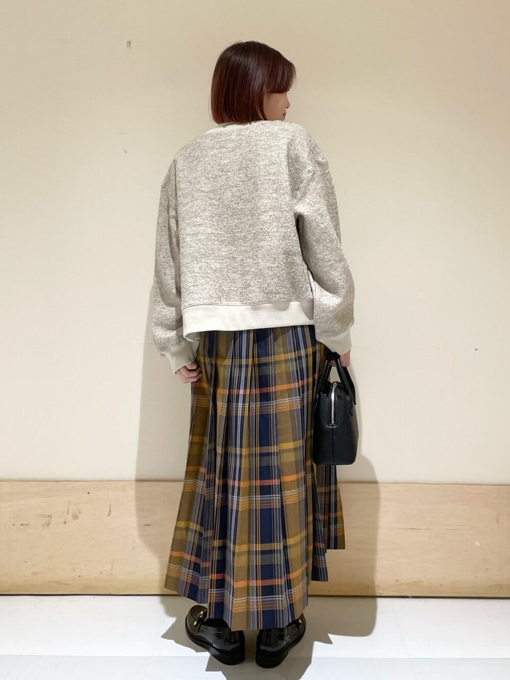 ホワイト系のTシャツ/カットソー、ブラック系のショルダーバッグ、ブラック系のレインシューズを着用したレディースの秋コーディネートの7枚目の写真