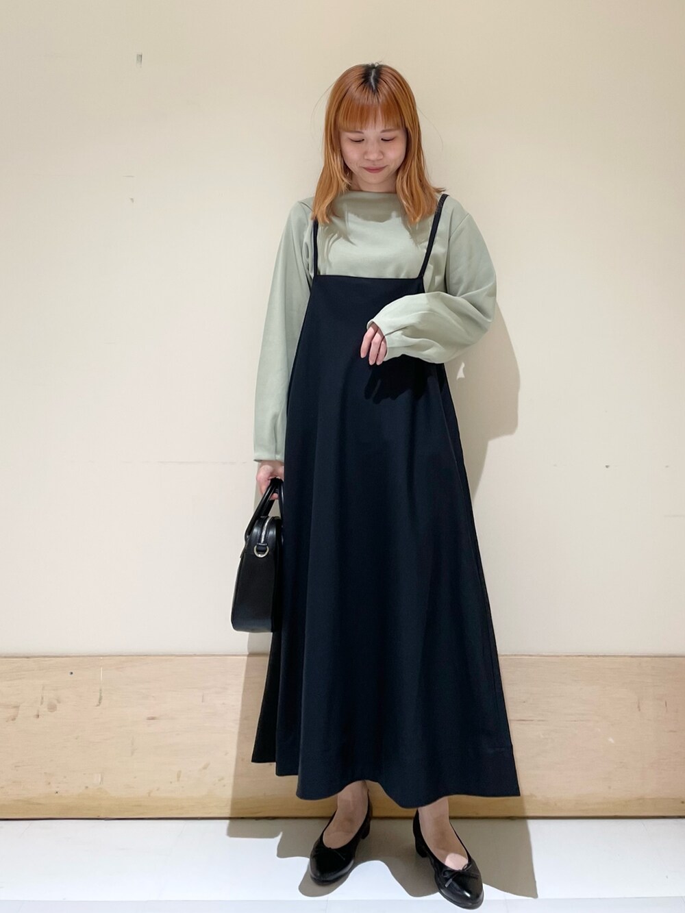 グリーン系のTシャツ/カットソー、ブラック系のバレエシューズ、ブラック系のショルダーバッグを着用したレディースの春コーディネートの3枚目の写真