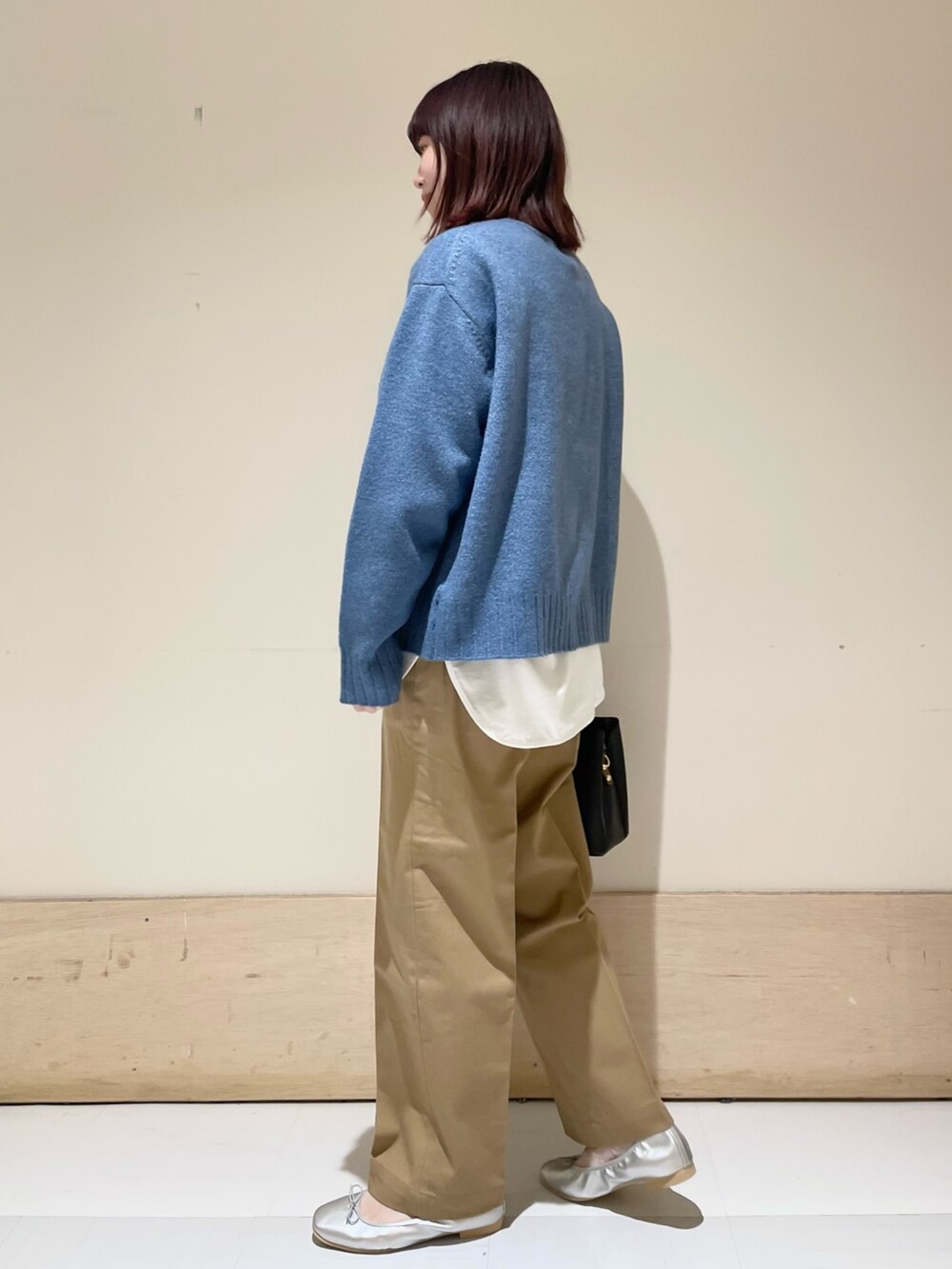 ホワイト系のTシャツ/カットソー、ブルー系のニット/セーター、シルバー系のバレエシューズを着用したレディースの冬コーディネートの4枚目の写真