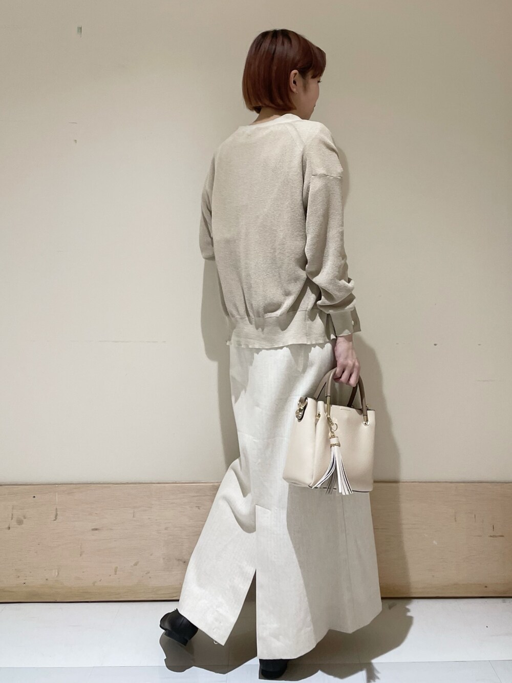 ベージュ系のスカート、ベージュ系のカーディガン/ボレロ、ホワイト系のTシャツ/カットソーを着用したレディースの春コーディネートの7枚目の写真