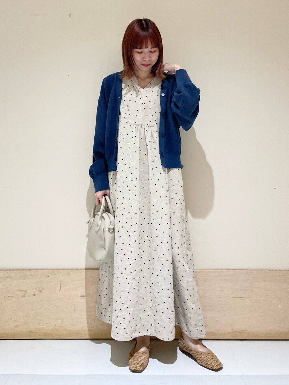 ベージュ系のショルダーバッグ、ベージュ系のパンプス、ブルー系のニット/セーターを着用したレディースの春コーディネートの2枚目の写真