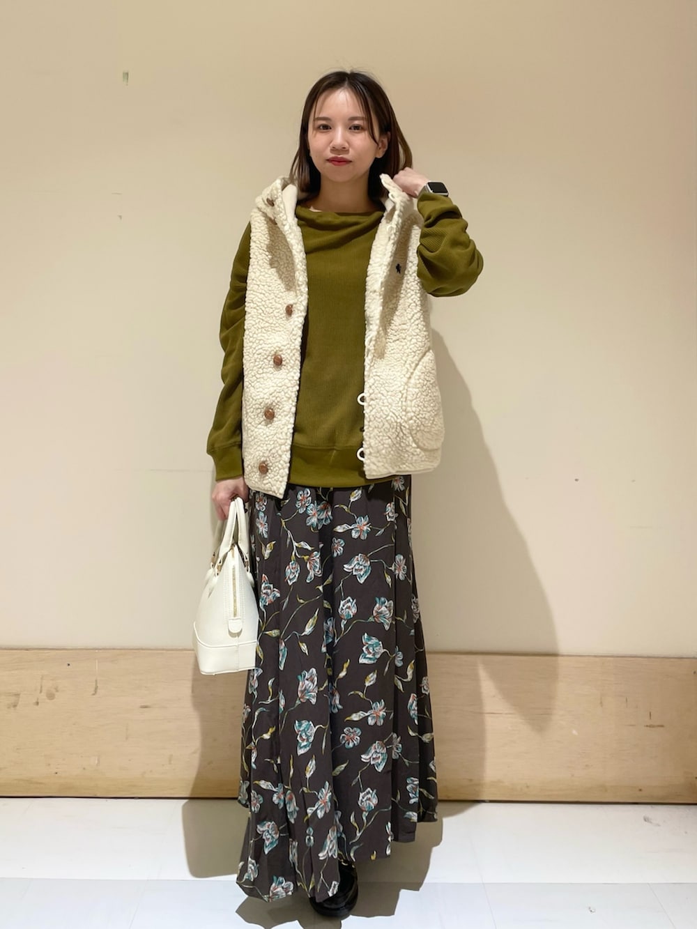 ホワイト系のショルダーバッグ、ブラック系のレインシューズ、イエロー系のTシャツ/カットソーを着用したレディースの秋コーディネートの2枚目の写真