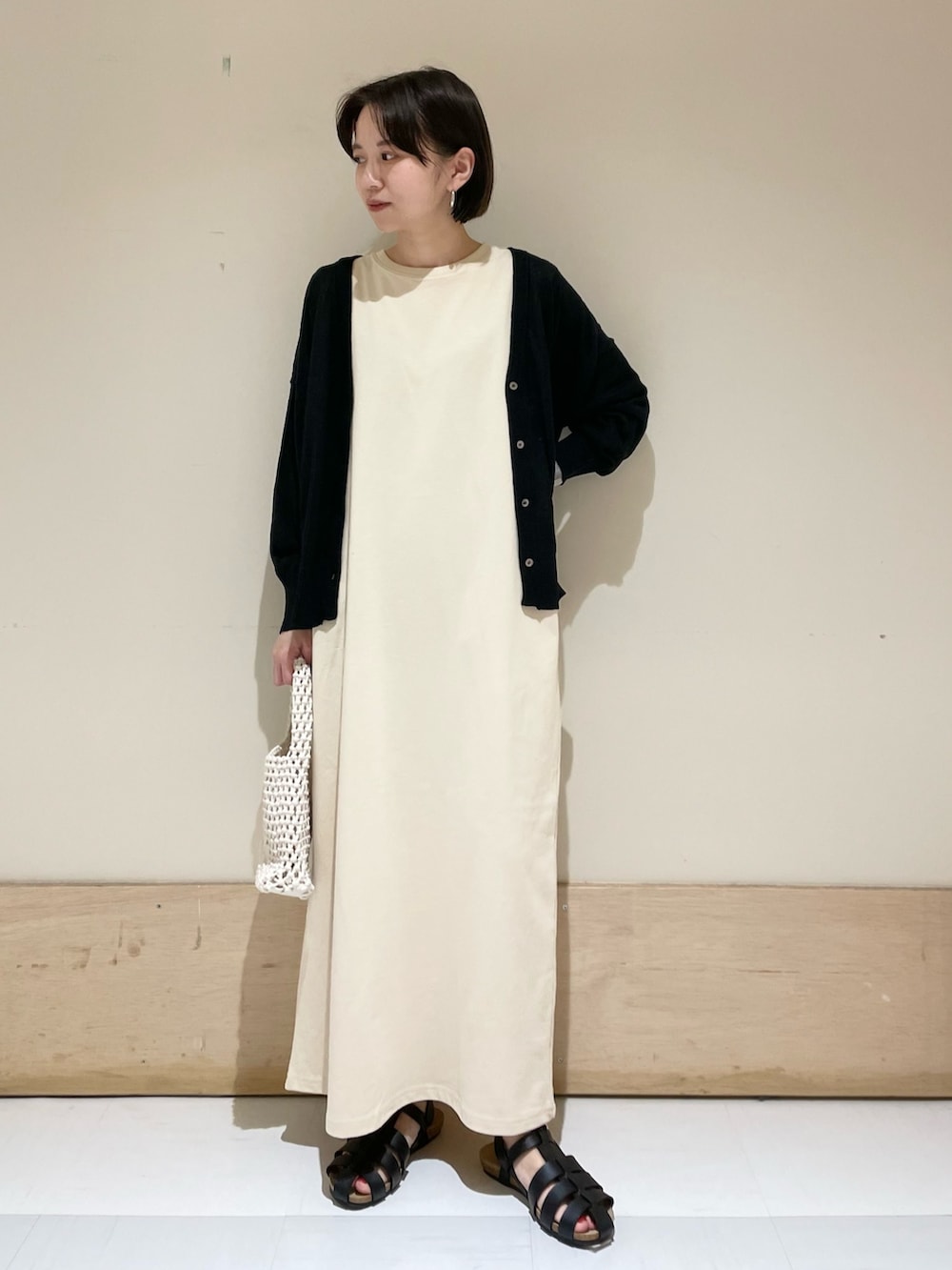 ベージュ系のワンピース、ブラック系のカーディガン/ボレロ、ブラック系のサンダルを着用したレディースの夏コーディネートの3枚目の写真
