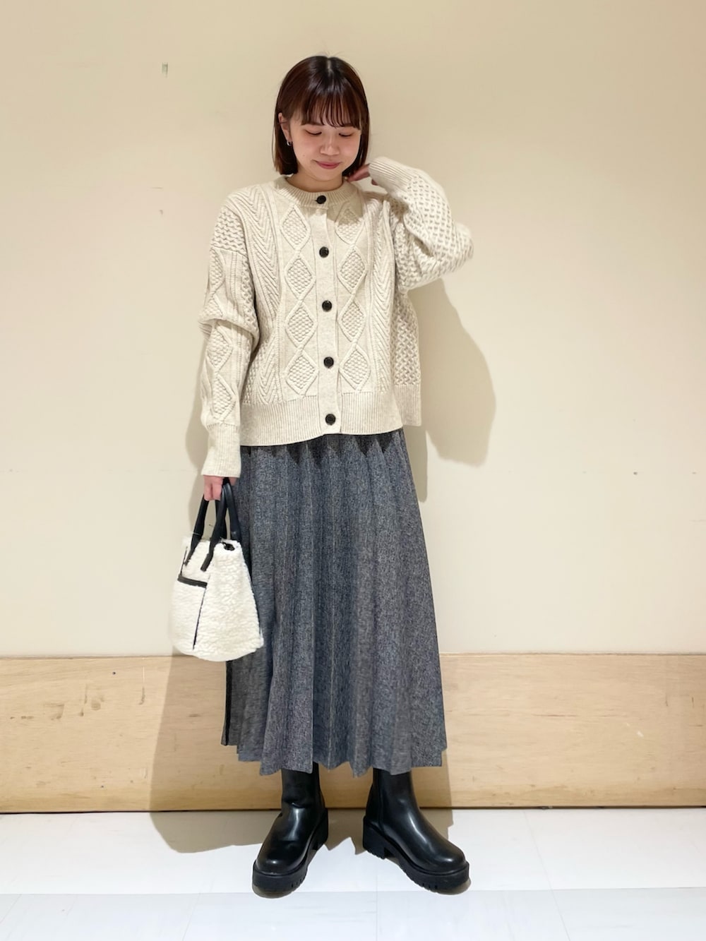 ホワイト系のカーディガン/ボレロ、ブルー系のスカート、ホワイト系のショルダーバッグを着用したレディースの冬コーディネートの3枚目の写真