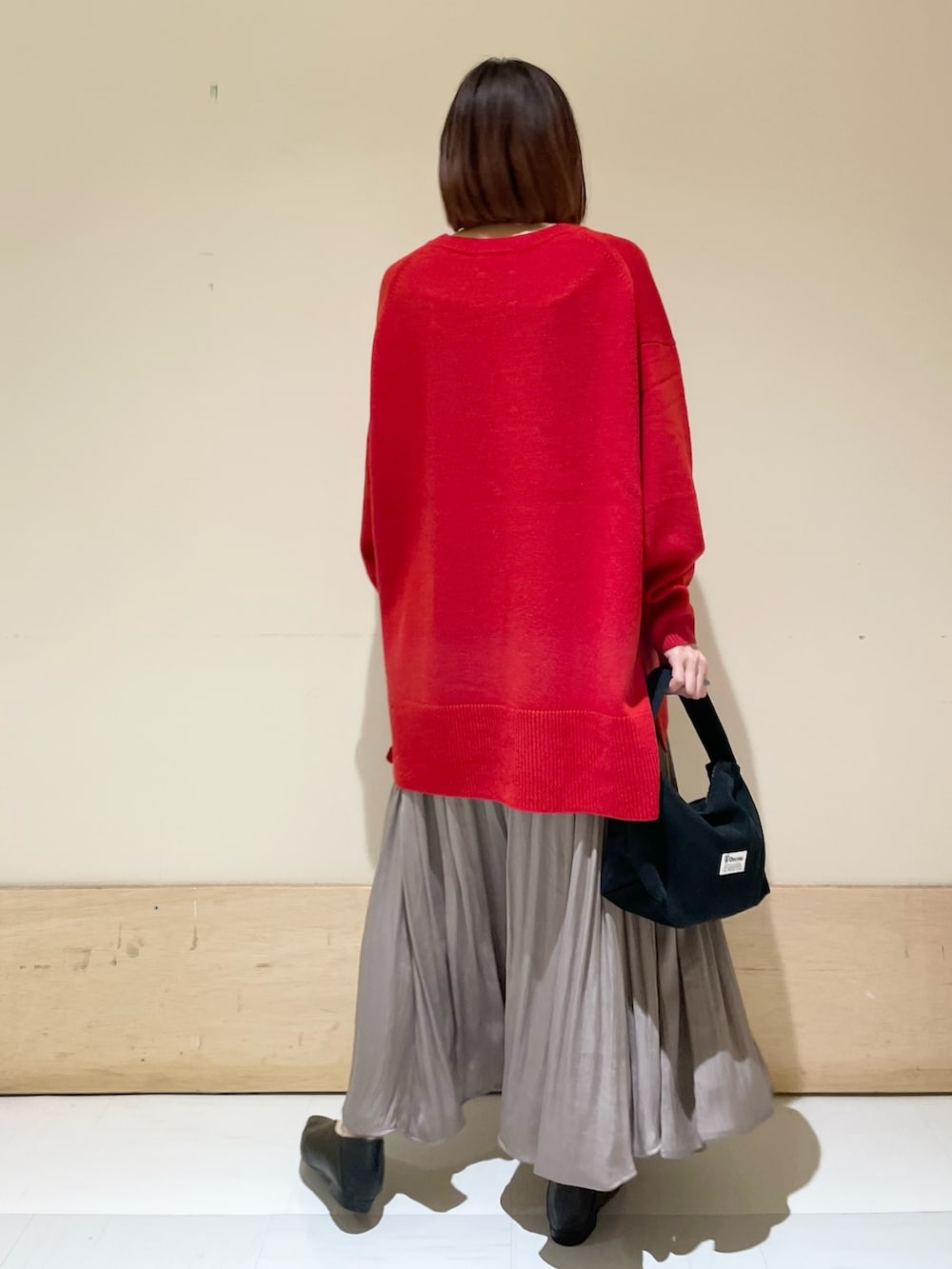 ブラック系のハンドバッグ、グレー系のスカート、ブラック系のパンプスを着用したレディースの秋コーディネートの5枚目の写真